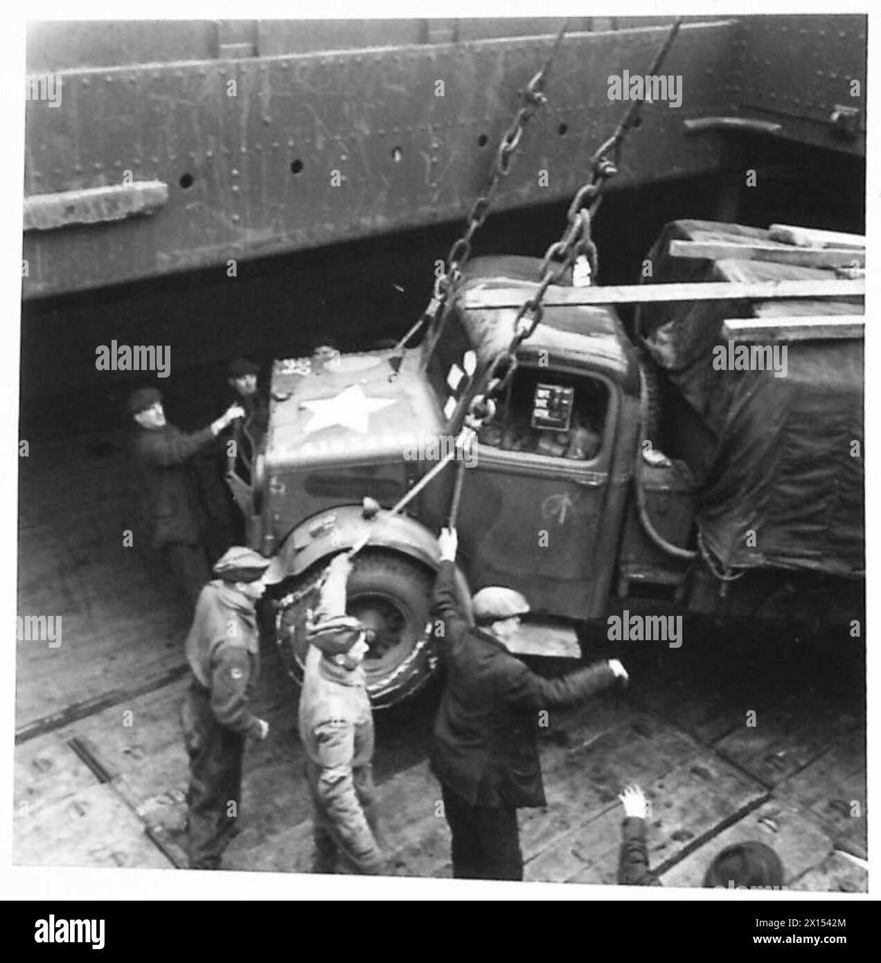 Le truppe britanniche e americane imbarcano un veicolo dalla banchina su una nave durante le operazioni congiunte. Foto Stock