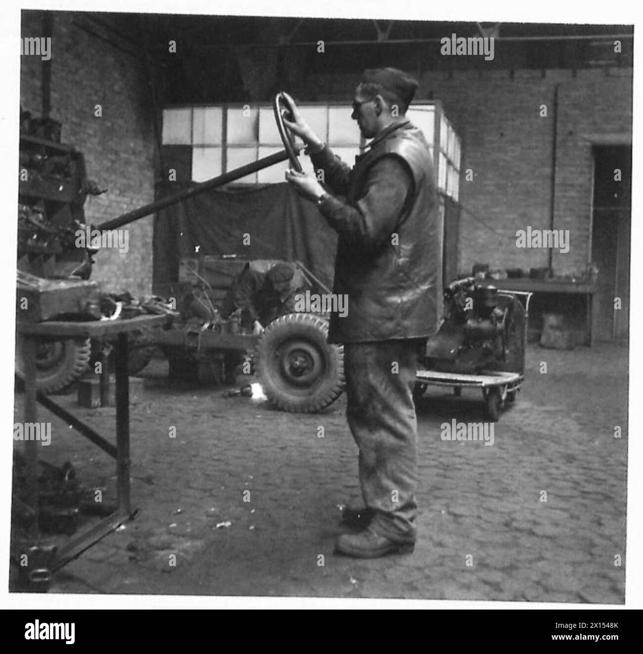 Le officine REME ricostruiscono e rinnovano Jeep per uso operativo da parte dell'esercito britannico, 21st Army Group, dimostrando manutenzione, riparazione e supporto logistico dei veicoli dell'esercito durante le operazioni post-combattimento. Foto Stock