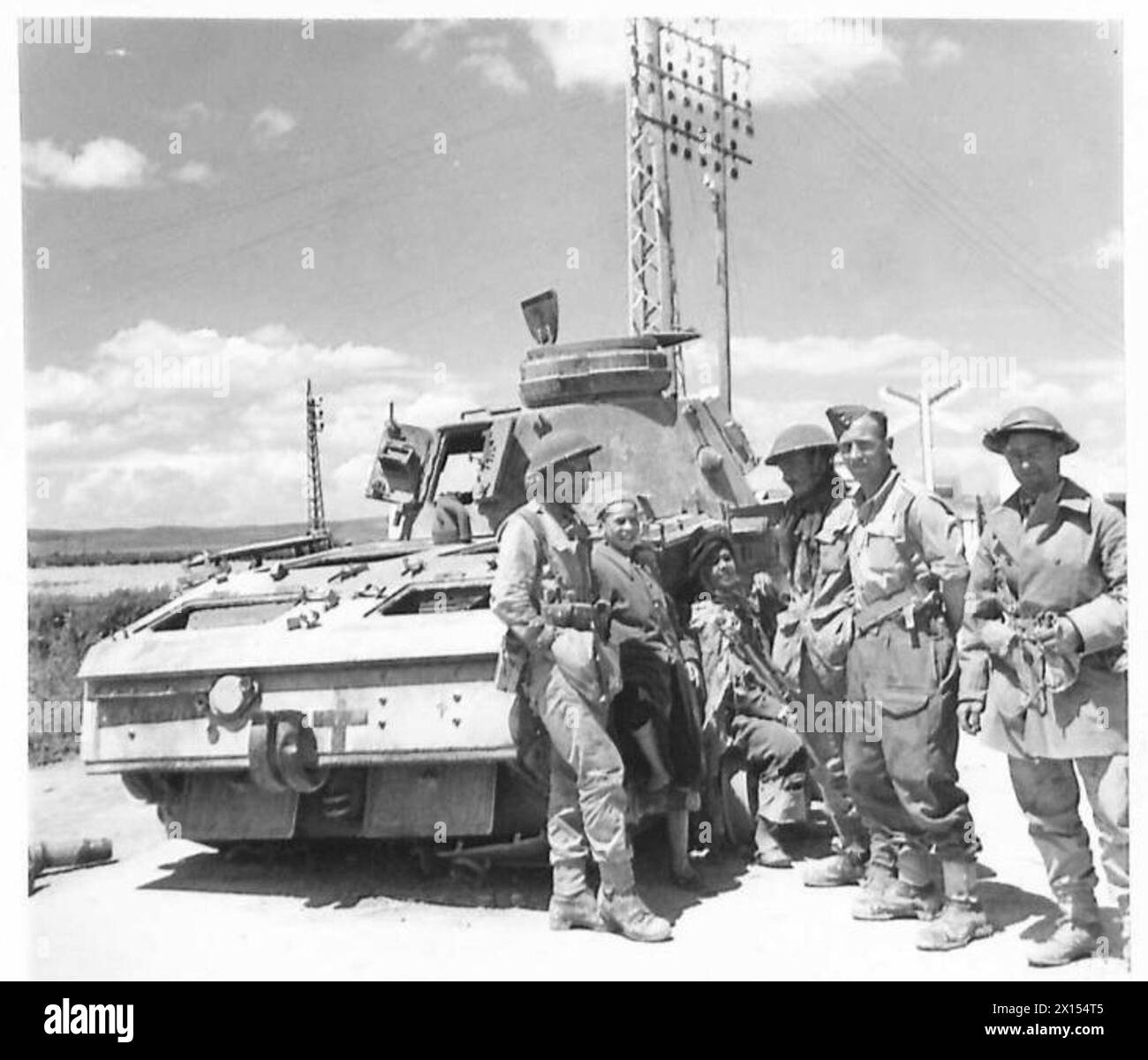 Soldati britannici della King's Shropshire Light Infantry (K.S.L.I.) conversando con civili locali accanto a un carro armato tedesco distrutto a Tebourba, in Tunisia, durante la seconda guerra mondiale Foto Stock