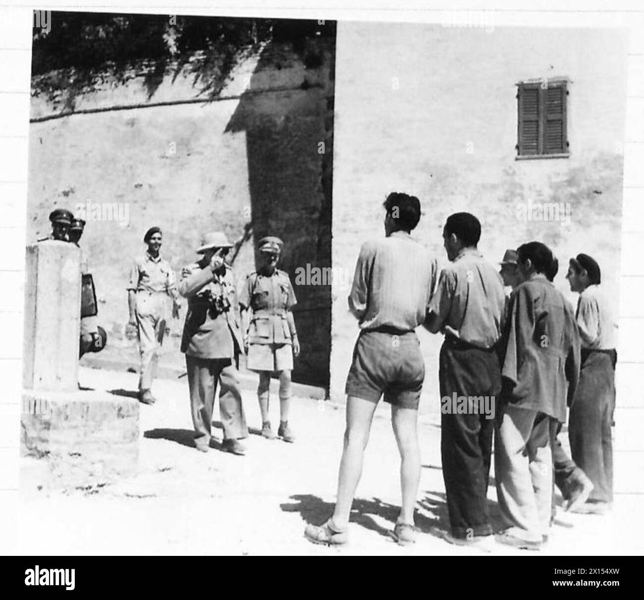 I civili italiani fanno il tifo per il primo ministro Winston Churchill mentre lascia il posto di osservazione durante la sua visita all'Ottava Armata. Foto Stock