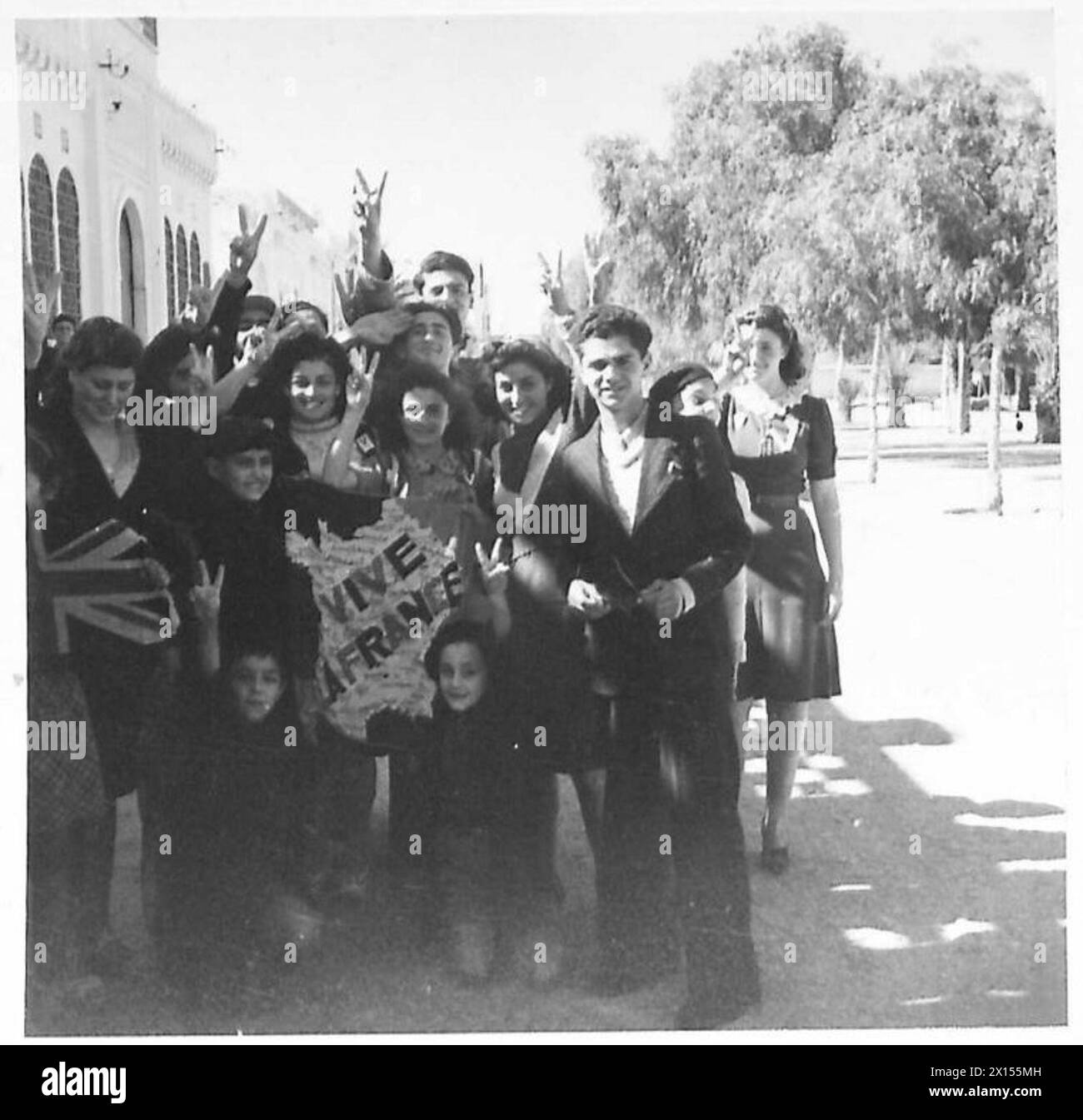 Le ragazze francesi tenevano una sciarpa con una mappa della Francia che recava "vive la France" dopo che le truppe della prima Armata britannica avevano catturato Kairouan. Foto Stock