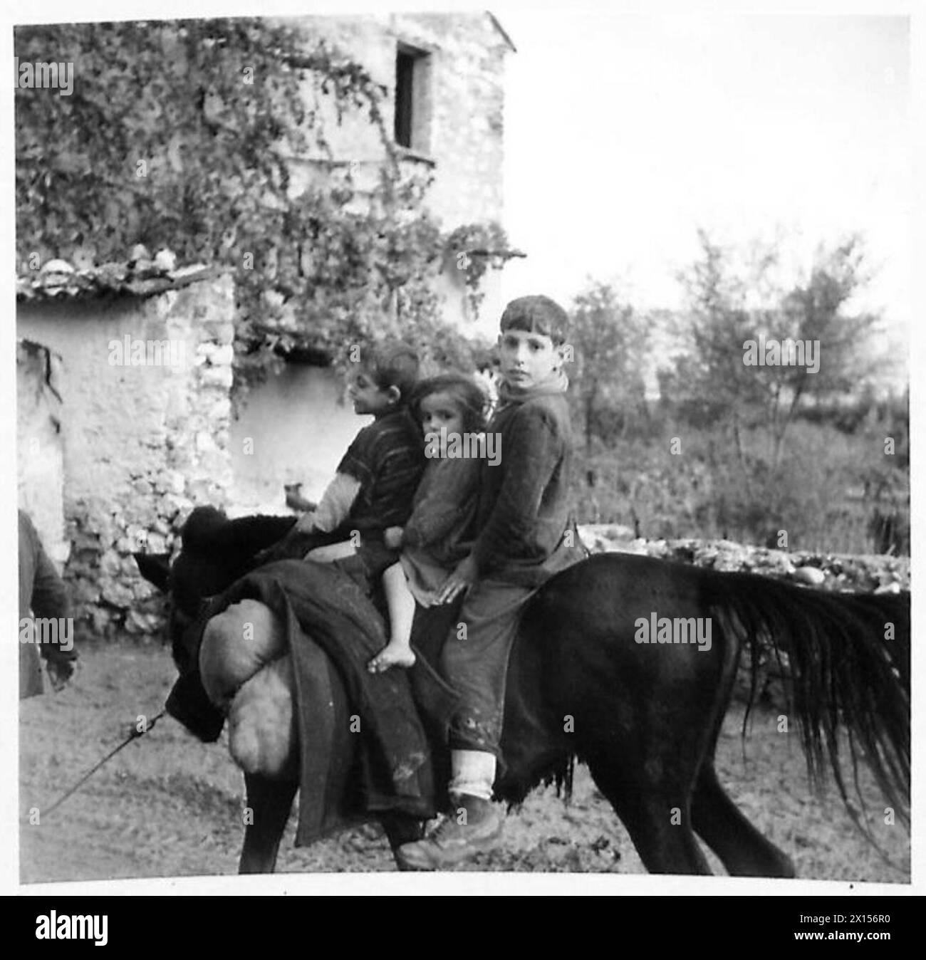 Tre bambini tornano a casa in un'area controllata dall'Ottava Armata in Italia. Foto Stock