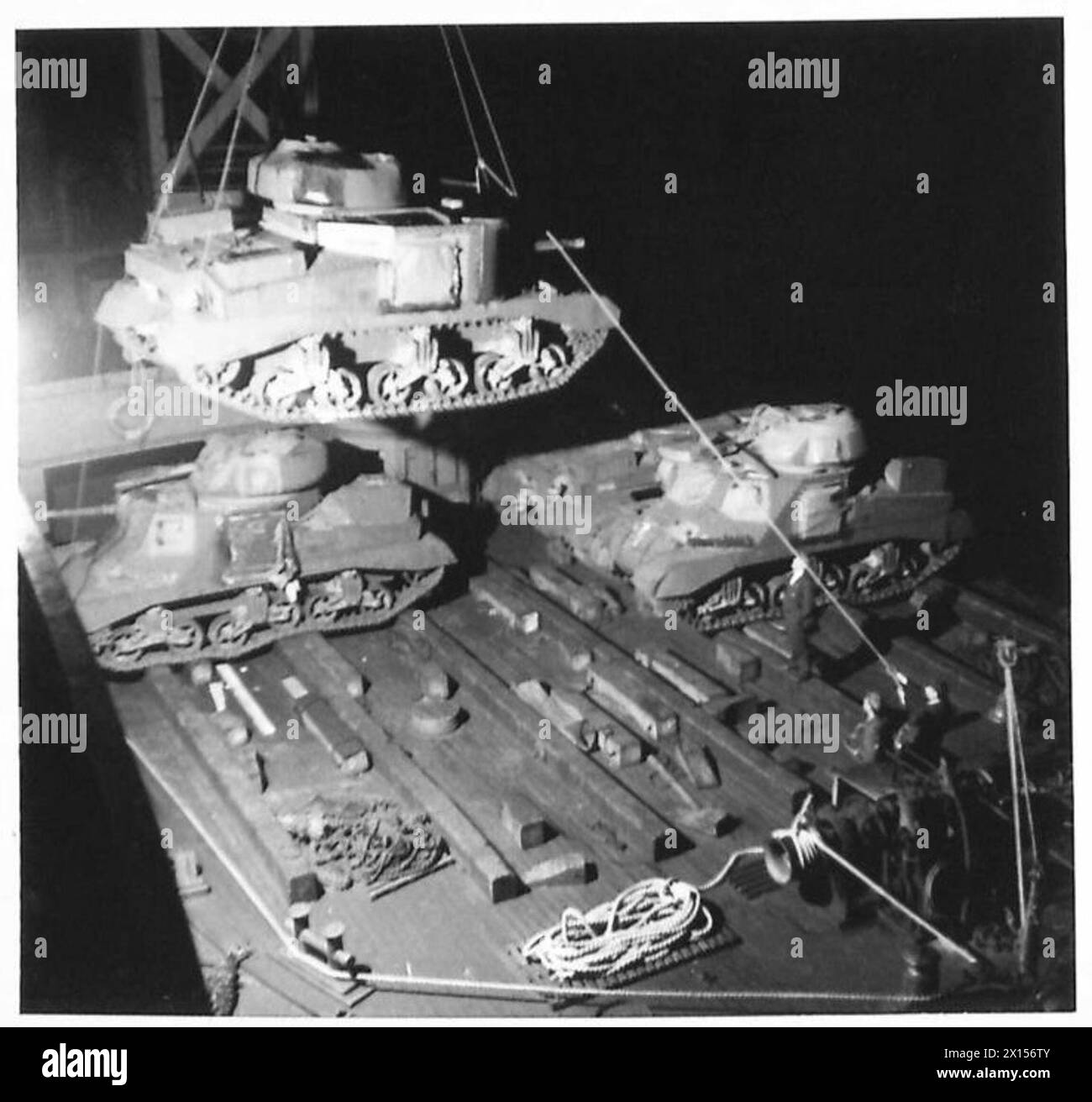 I carri armati General Grant vengono scaricati da una nave a una gru galleggiante, giorno e notte, illustrando lo spiegamento dei corazzati e le operazioni logistiche. Foto Stock