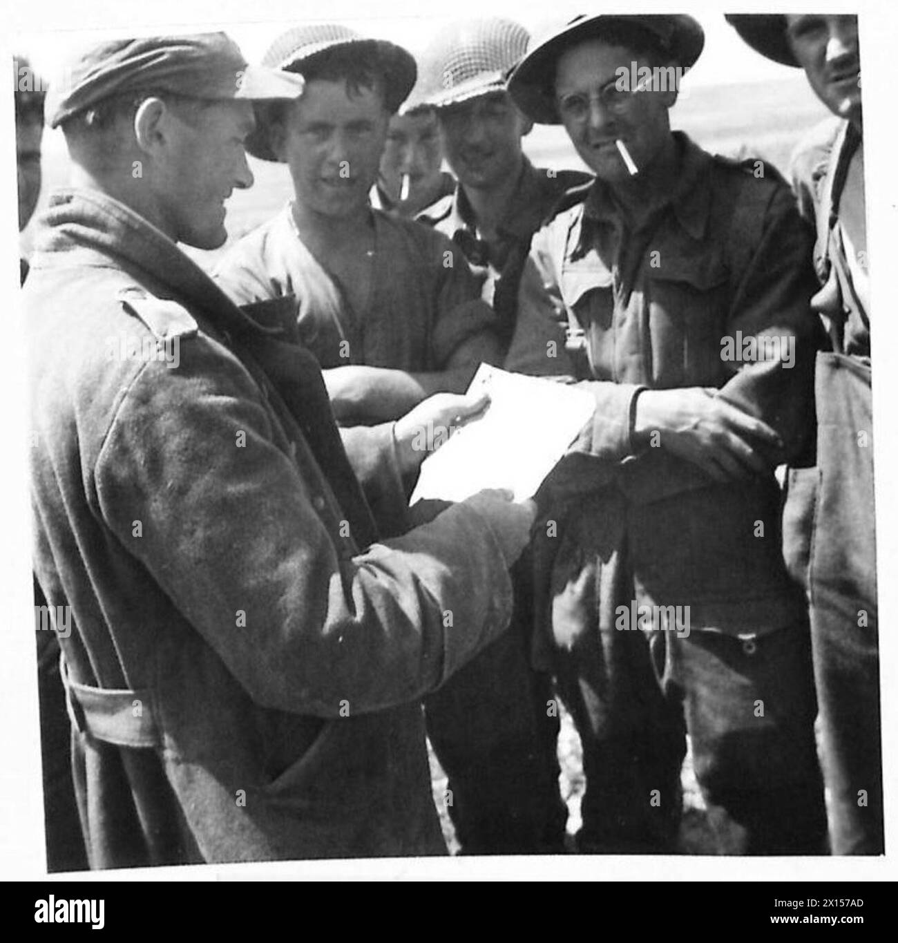 Un prigioniero tedesco nella zona della prima Armata ad est di Crich El Oued legge un opuscolo rilasciato dalla RAF sulle linee nemiche. Foto Stock