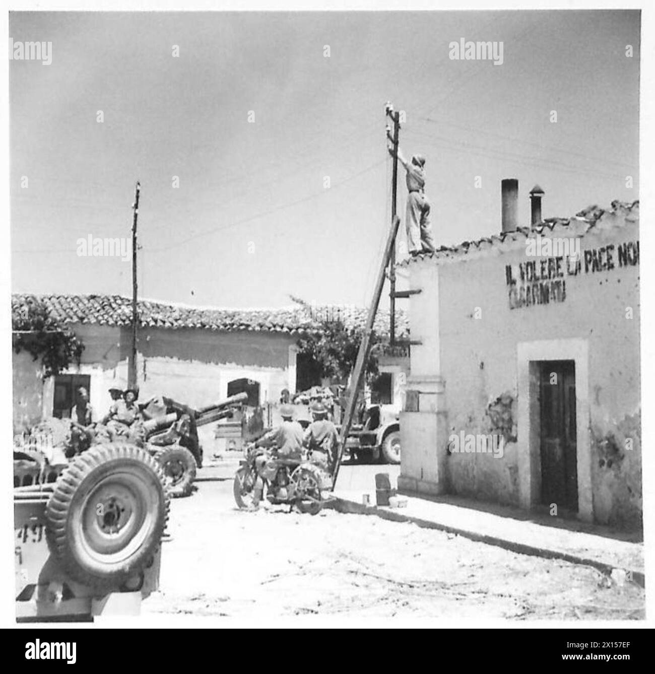 I segnalatori ripararono i cavi telefonici a Villasmuno poco dopo la cattura della città. Le unità di artiglieria si stavano spostando in posizione durante le prime fasi dell'invasione della Sicilia. Foto Stock