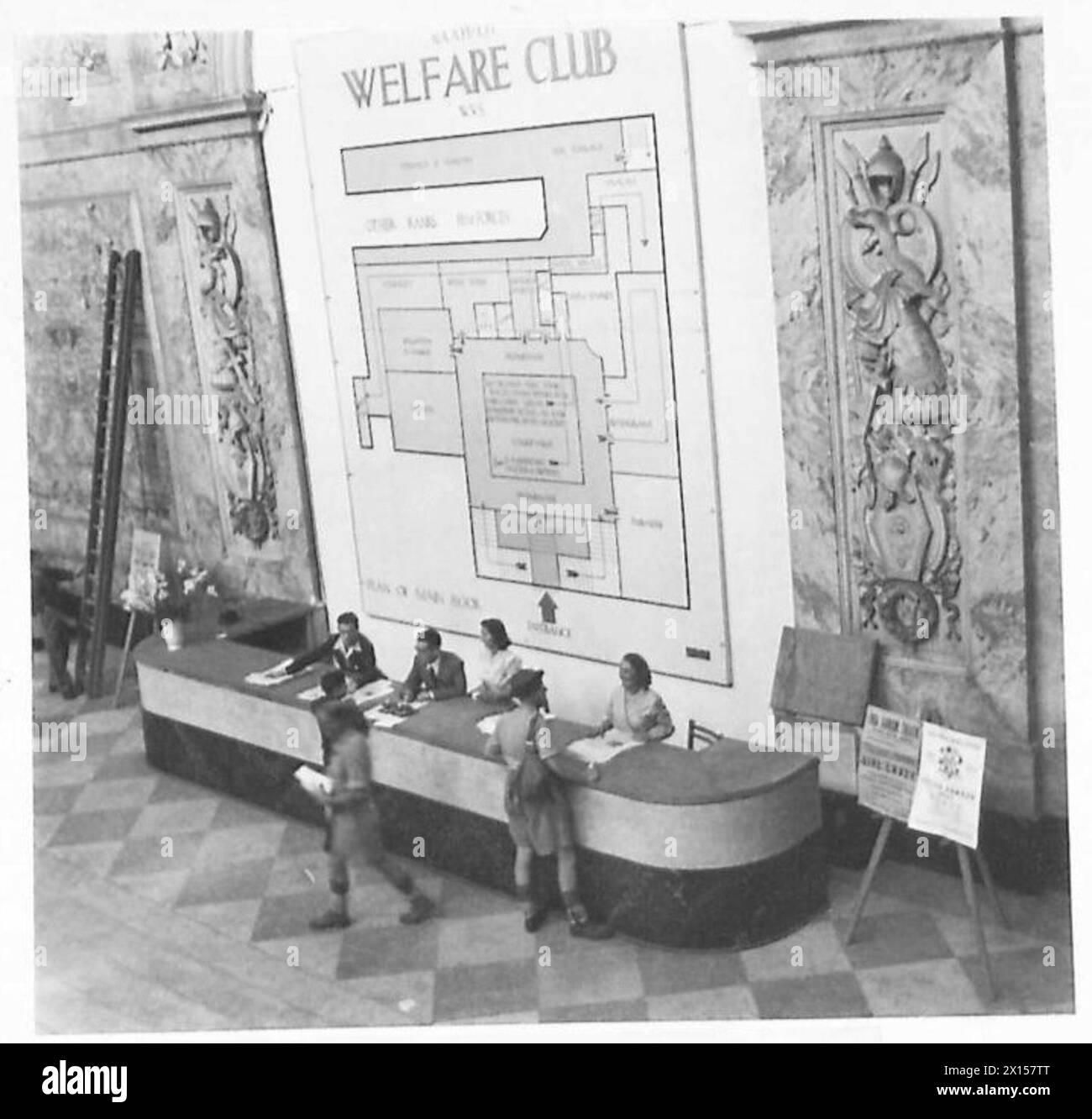 Private Smith è al banco dell'Ufficio informazioni ai piedi di una grande scalinata in Italia. Foto Stock