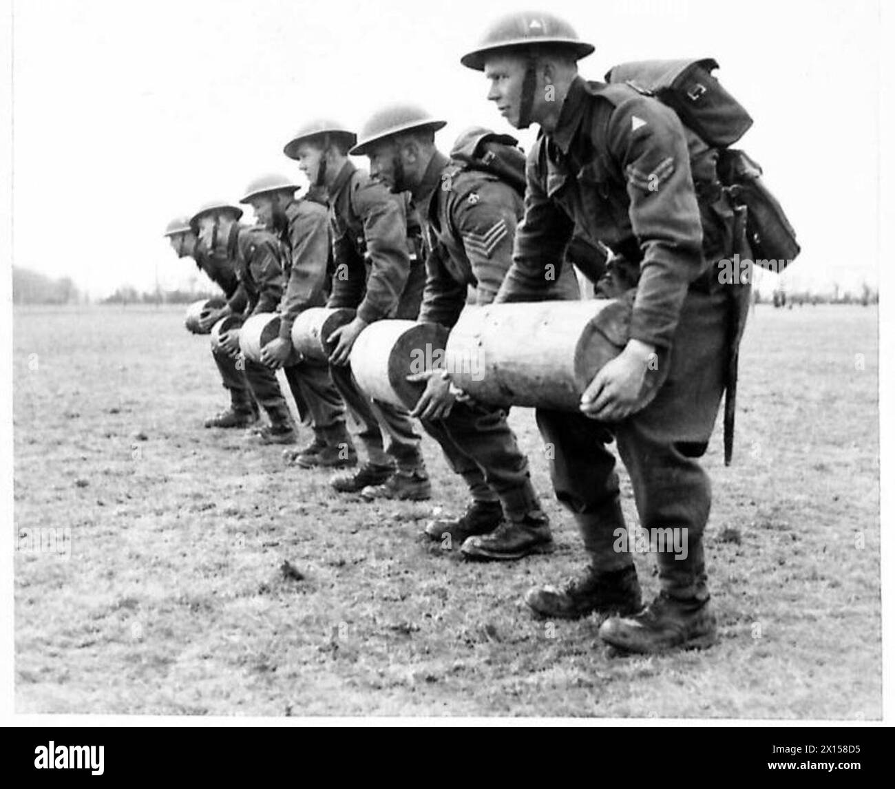 HARGHENING UP - uomini che fanno esercizi con pesanti tronchi di legno per rendere i loro muscoli morbidi British Army Foto Stock