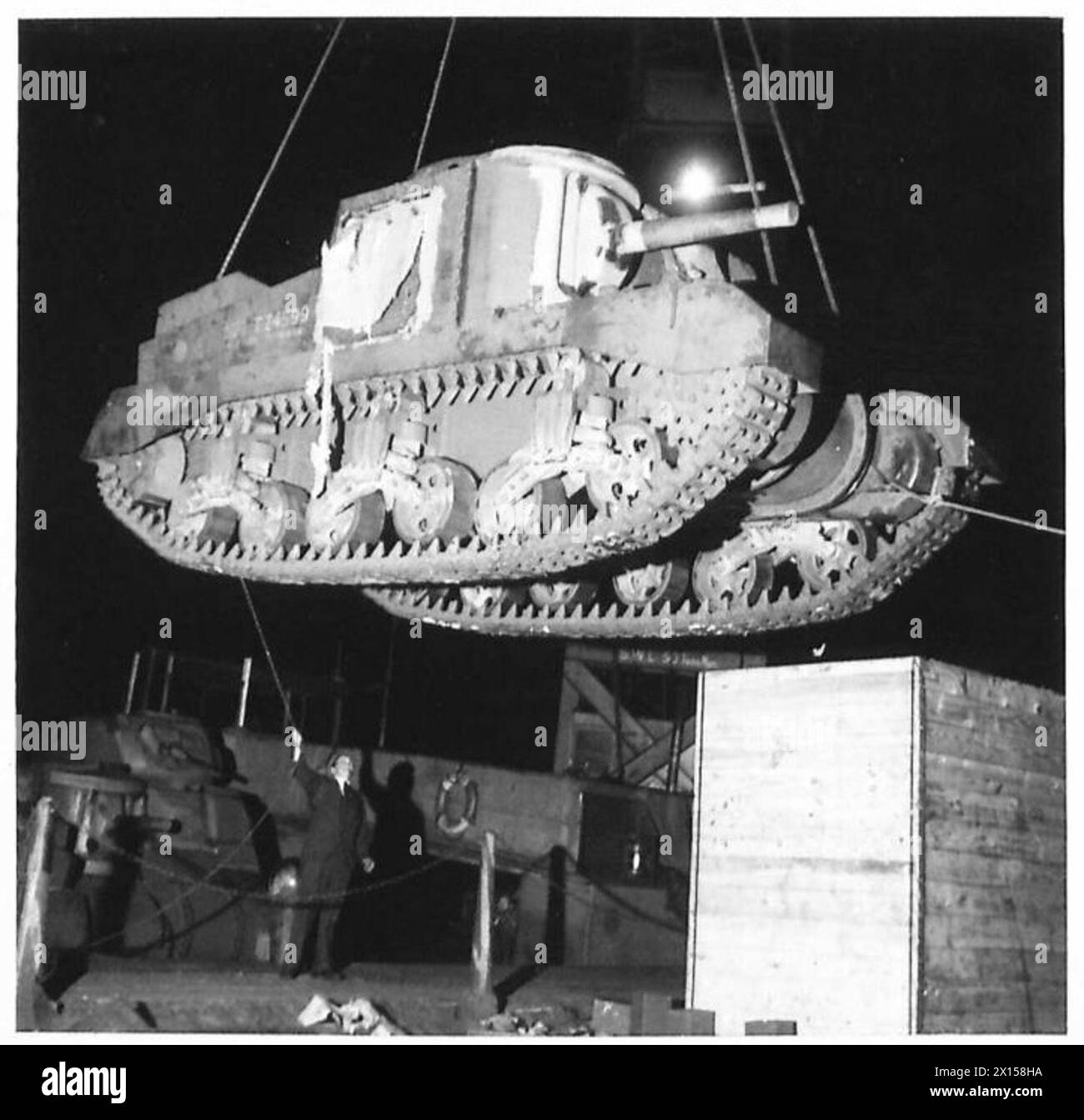 I carri armati del generale Grant vengono scaricati dalla stiva di una nave su un ponte di gru galleggiante durante le operazioni diurne e notturne dell'esercito britannico. Foto Stock