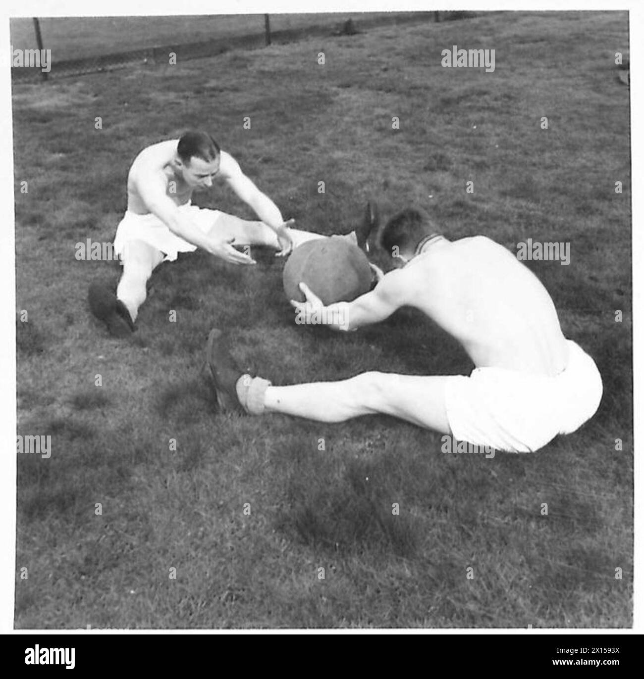 Il tenente colonnello Harper e gli istruttori dell'Army P.T. dimostrano esercizi di palla di medicina all'Hendon College per essere inclusi in un opuscolo dell'Army P.T. Foto Stock