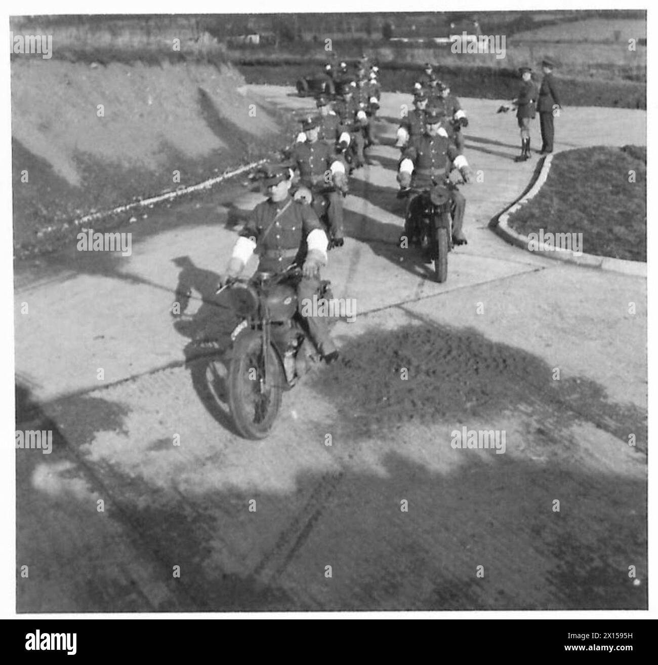 Una squadra di poliziotti militari dell'esercito britannico inizia una corsa di addestramento su motociclette, esercitando la mobilità e il coordinamento per la preparazione operativa. Foto Stock