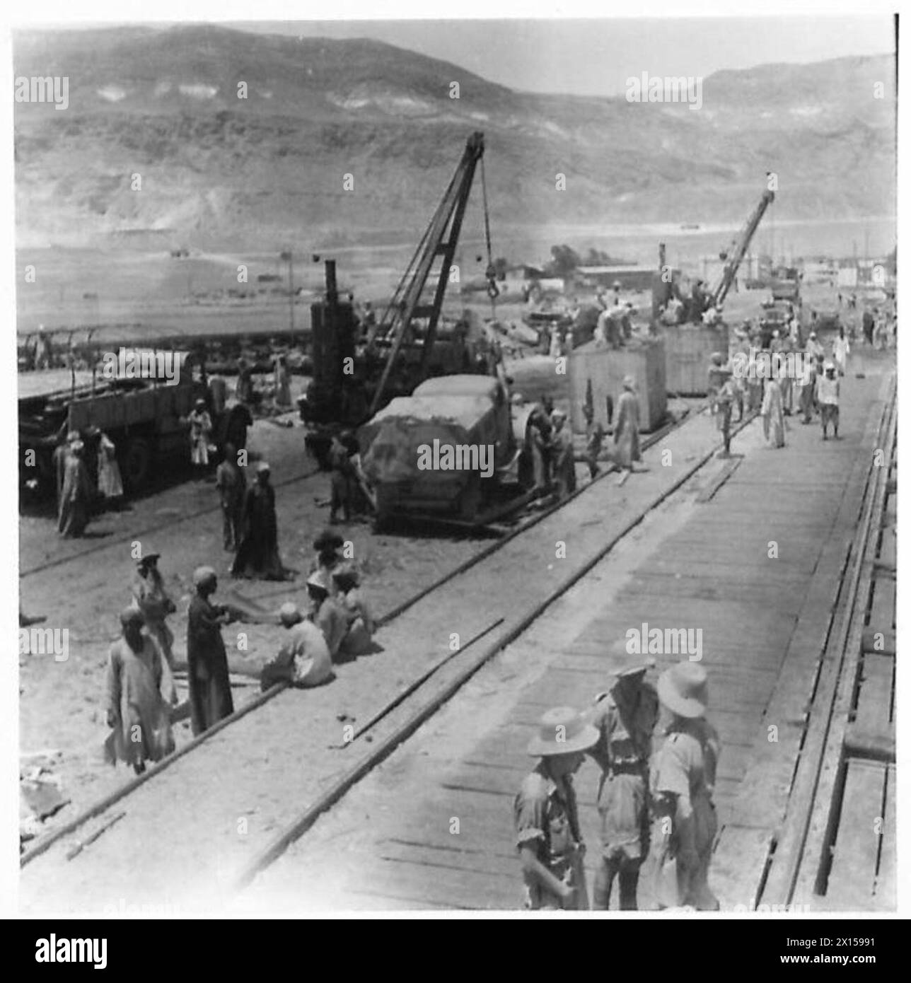 Auto e camion vengono scaricati e assemblati in una banchina in Nord Africa e Medio Oriente da personale dell'esercito britannico. Foto Stock