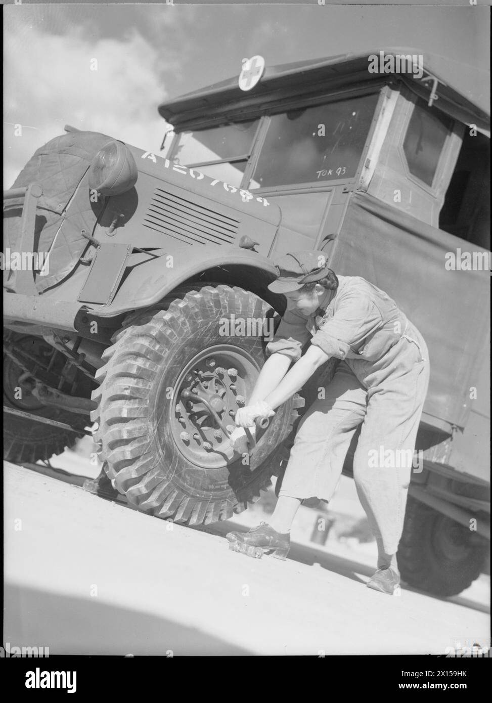 CORSO DI FORMAZIONE SULLA MANUTENZIONE DEL VEICOLO per IL SERVIZIO TERRITORIALE AUSILIARIO, 1942 - Un membro dell'ATS cambia la ruota di un veicolo industriale nell'ambito della sua formazione per i conducenti. È possibile che questa fotografia sia stata scattata al centro di formazione di Camberley, nel Surrey Foto Stock