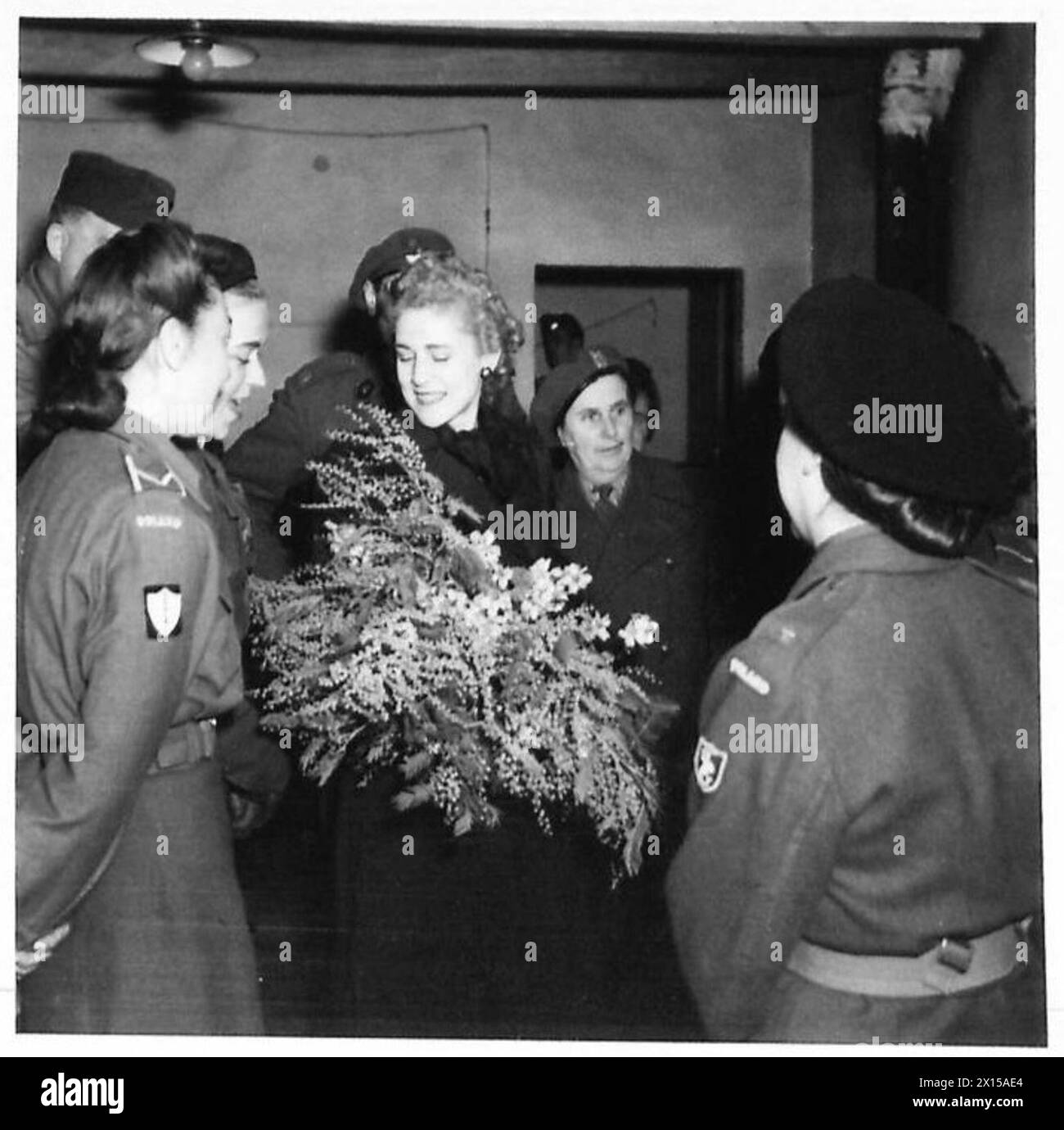 La signora Clare Booth luce riceve fiori da un membro del servizio ausiliario femminile, II corpo polacco, durante la sua visita nel settore britannico dell'VIII Armata a Meldola, 18 marzo 1945. Foto Stock