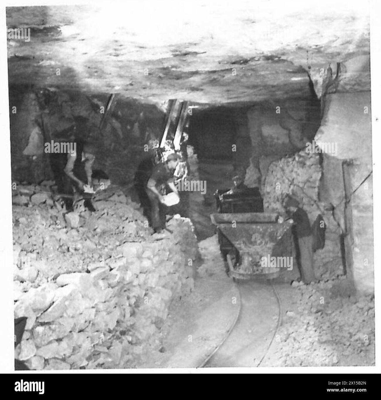 Gli operai costruiscono un tunnel in un enorme deposito sotterraneo di munizioni, caricando pietre in un salto. Foto Stock