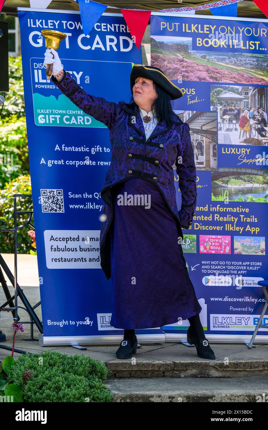 Donna pigriera e cameriera (abiti da livrea da donna) che fa annunci e annunci pubblici rumorosi - Ilkley, West Yorkshire, Inghilterra Regno Unito. Foto Stock