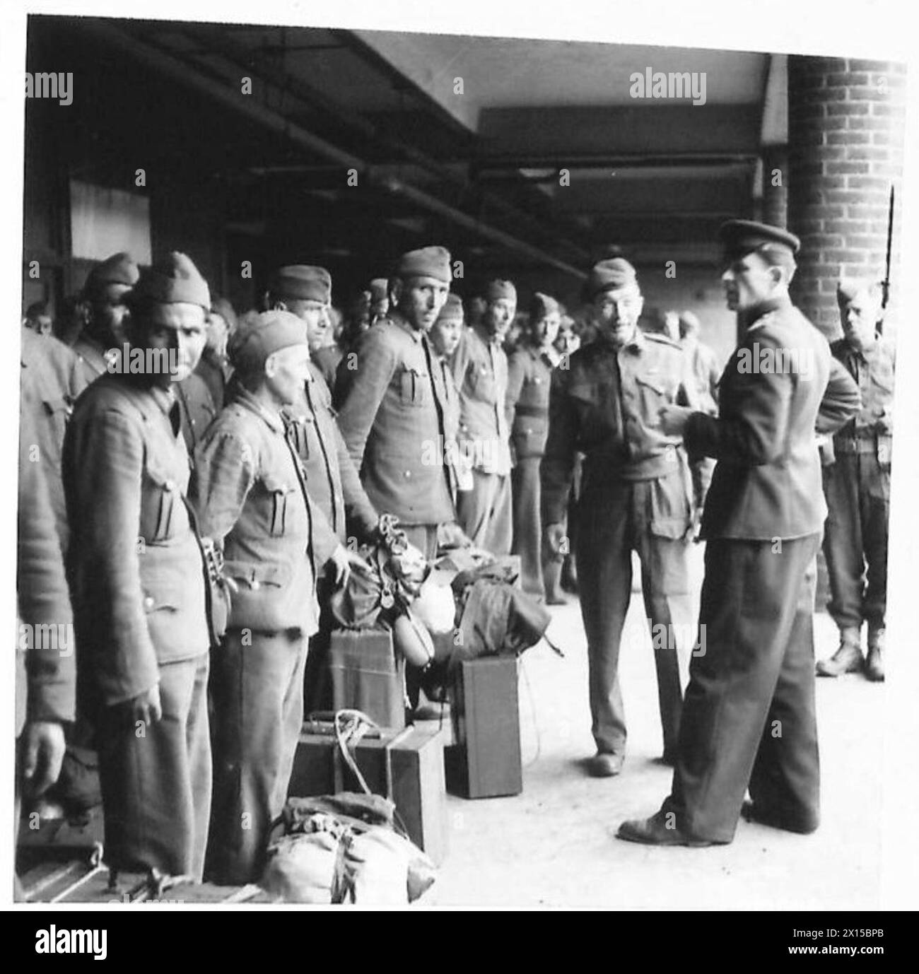 Al No.9 P.O.W. Reception Camp, i cittadini russi alleati arruolati nell'esercito tedesco sono ordinati e indirizzati da un ufficiale russo, l'esercito britannico. Foto Stock