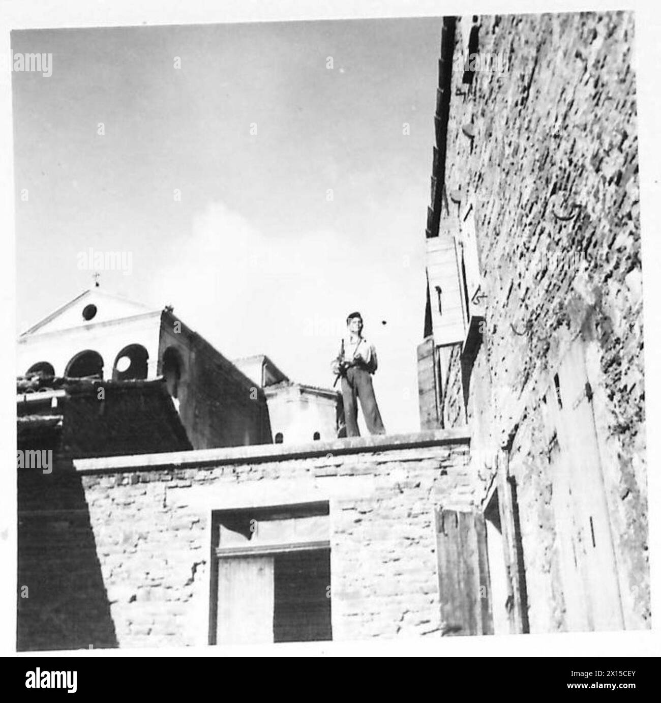 Una sentinella partigiana è stazionata su un tetto piatto che sovrintende a tutti gli approcci a un villaggio durante le operazioni dell'esercito britannico in Nord Africa, Sicilia, Italia, Balcani e Austria, 1942-1946. Foto Stock