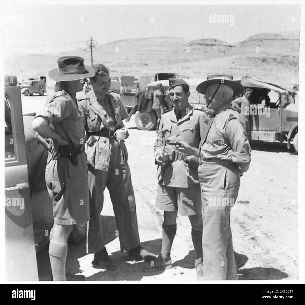 Il maggiore generale E.C. Peant, A.I.F., e il maggiore W.J. Balchin, A.I.F., parlano con un ufficiale della RAF e un giornalista americano nel deserto occidentale. Foto Stock