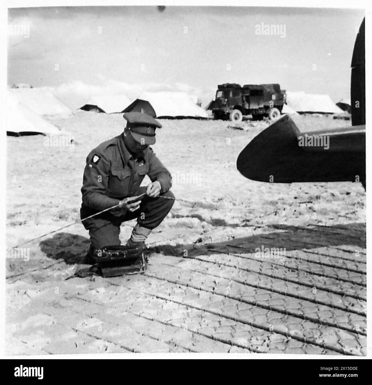 Sgmn. T. Lilley dei segnali della British Army Air Formation ripara una linea di comunicazione interrotta all'aeroporto anteriore sul fronte dell'8th Army, supportando le operazioni della RAF all'estero. Foto Stock
