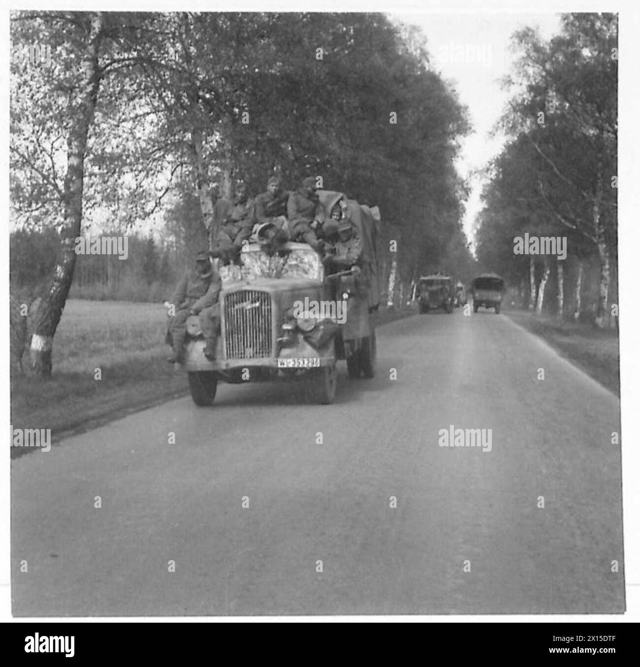 I soldati tedeschi si arrendono mentre viaggiano attraverso le linee britanniche utilizzando i propri veicoli dell'esercito, come parte di una resa di massa osservata dal 21st Army Group durante la seconda guerra mondiale Foto Stock I soldati tedeschi si arrendono mentre viaggiano attraverso le linee britanniche utilizzando i propri veicoli dell'esercito, come parte di una resa di massa osservata dal 21st Army Group durante la seconda guerra mondiale Foto Stock