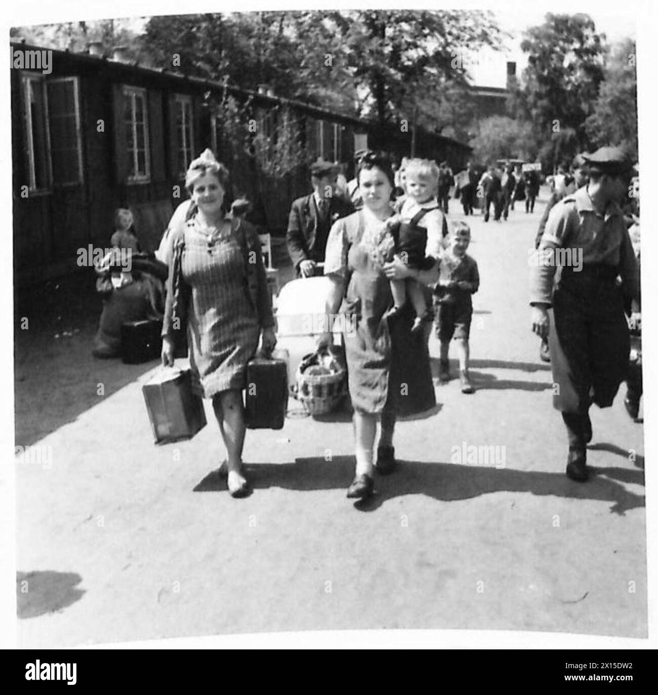 SFOLLATI E RIFUGIATI IN GERMANIA - un'altra famiglia polacca entra nel campo, Maria Klarecka con il suo figlioletto. Il campo degli sfollati all'interno del parco dello zoo di Amburgo fu costruito dalla compagnia Blohm & Voss durante la seconda guerra mondiale per ospitare i lavoratori forzati che lavoravano nella loro fabbrica. Il campo fu conquistato dagli inglesi il 5 maggio 1945 e rapidamente consegnato come centro di arrivo per gli sfollati. All'arrivo gli sfollati sono stati organizzati in gruppi di 50 persone da elaborare attraverso il centro di accoglienza. Sono stati spolverati con polvere anti-pidocchi e hanno ricevuto una scheda di registrazione (D.P.3) Foto Stock