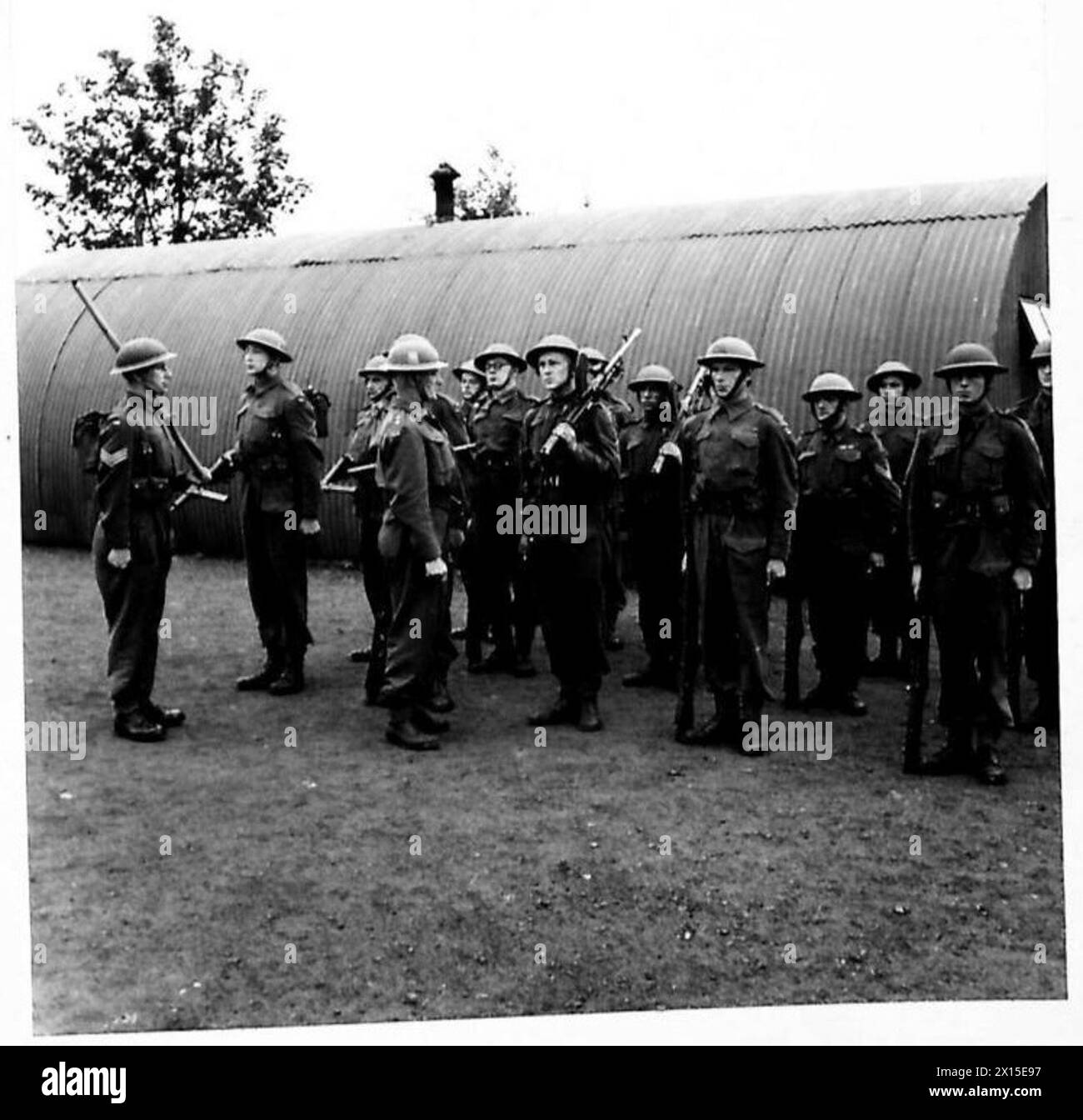 Una sezione di soldati in Irlanda del Nord si prepara ad un'esercitazione di addestramento pionieristico sotto ispezione del comandante della compagnia. Foto Stock