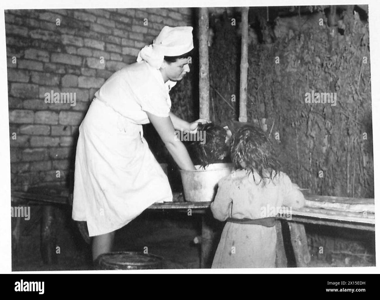 I bambini salvati dalla Terra di nessuno vengono trattati in un campo di transito dove gli infermieri li lavano e li puliscono dopo aver vissuto in condizioni esposte, prima di stampare un giornale gratuito, British Army, 21st Army Group. Foto Stock