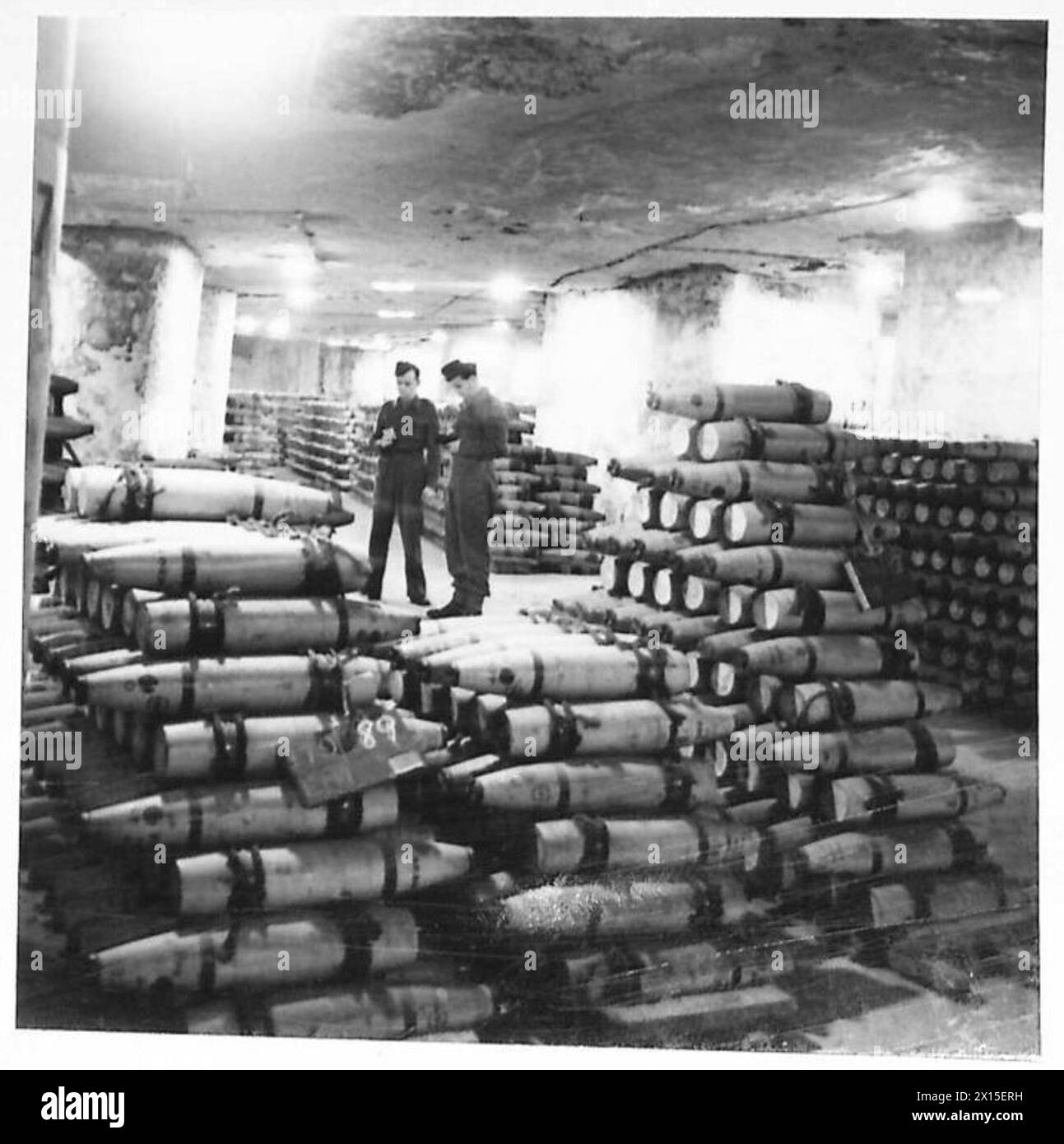 Agenti che ispezionano vari proiettili immagazzinati nelle baie sotterranee delle cave come parte dei preparativi per il secondo fronte. Foto Stock