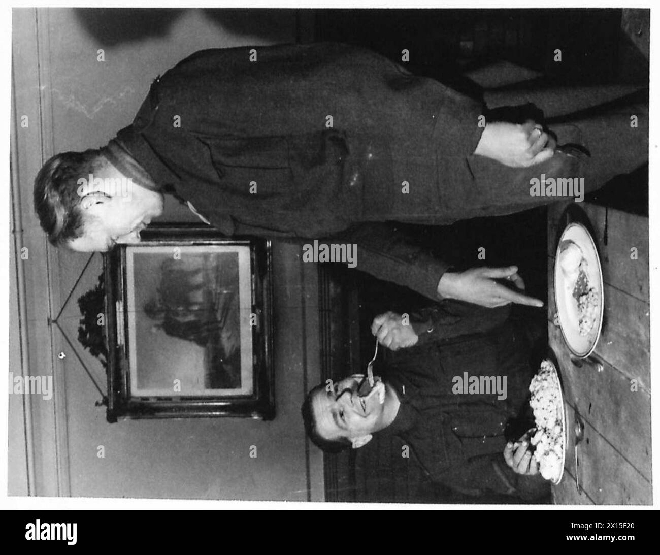 Due soldati sono mostrati con porzioni di pasto contrastanti, evidenziando gli atteggiamenti verso il consumo di cibo nell'esercito britannico. Foto Stock