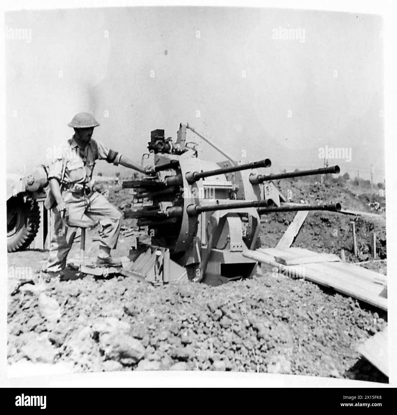 Un soldato ispeziona un cannone antiaereo da 20 mm a quattro canne catturato fuori dall'aeroporto di Salerno durante le operazioni della Quinta Armata in Italia. Foto Stock