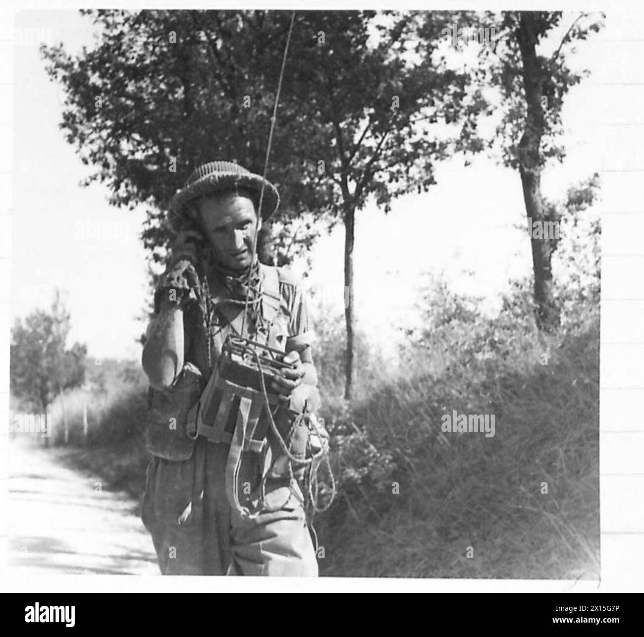 Un segnalatore del 5th Sherwood Foresters gestisce il suo set di comunicazione No.38 mentre cammina in archivio lungo una strada durante l'avanzata dell'Ottava Armata verso la linea Gotica. Foto Stock