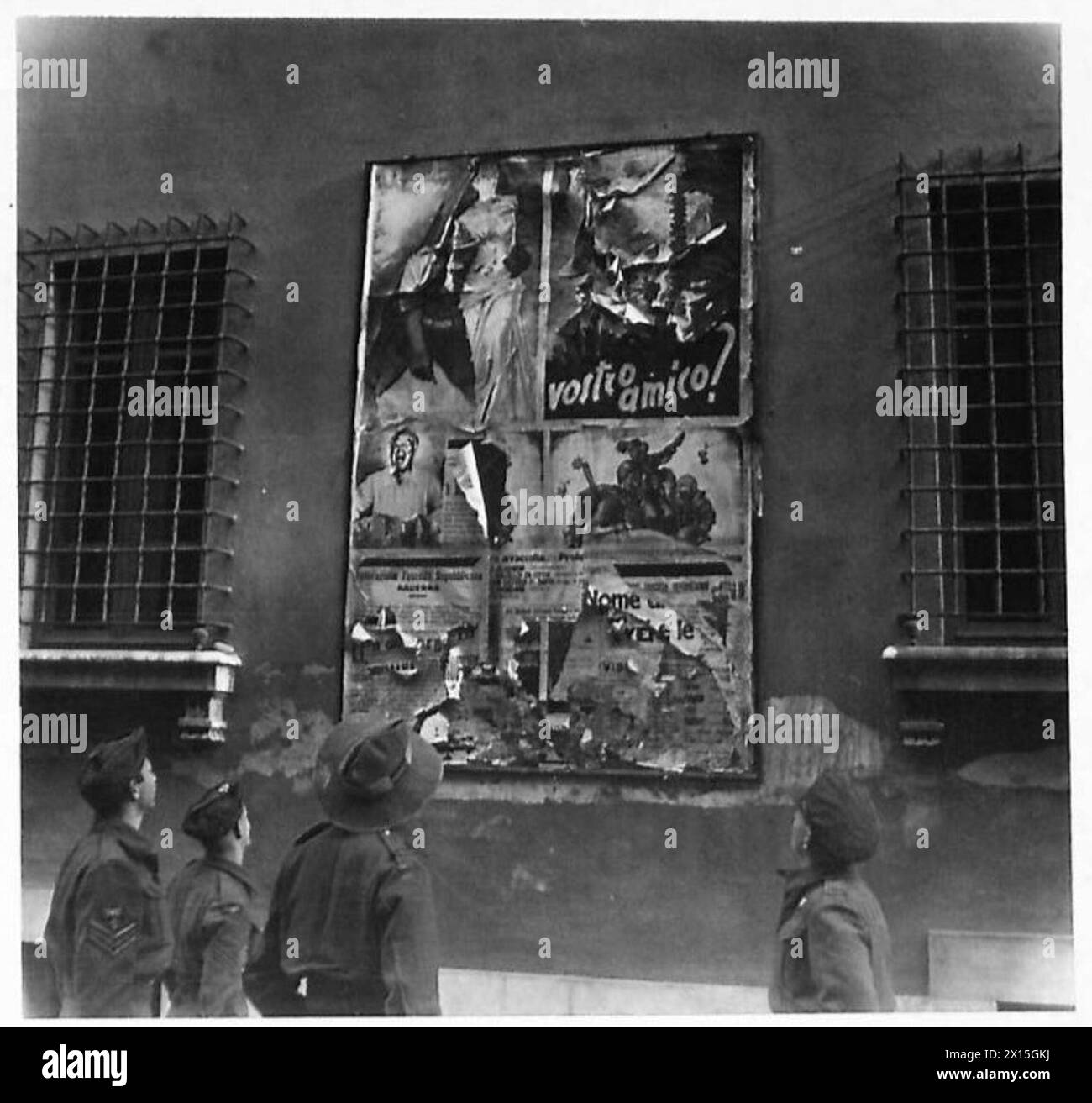 I piloti di caccia neozelandesi a Ravenna osservano un poster di propaganda tedesca con un soldato americano colorato e una statua di Venere di Milo, con il presidente Roosevelt presente. Foto Stock
