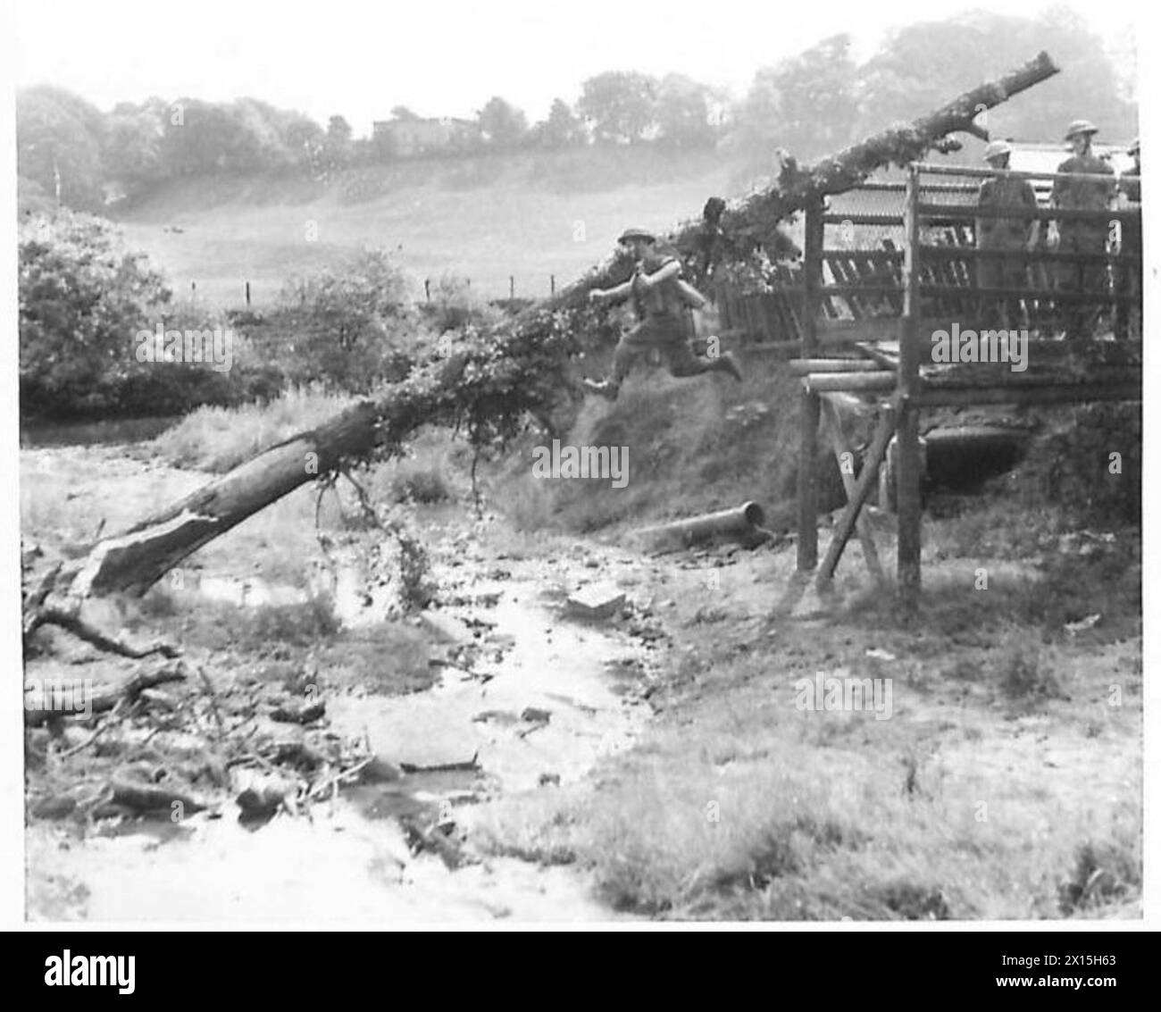 La fanteria attraversa un ruscello e protegge la riva opposta durante un'esercitazione d'assalto dell'esercito britannico per i lavoratori delle fabbriche. Foto Stock