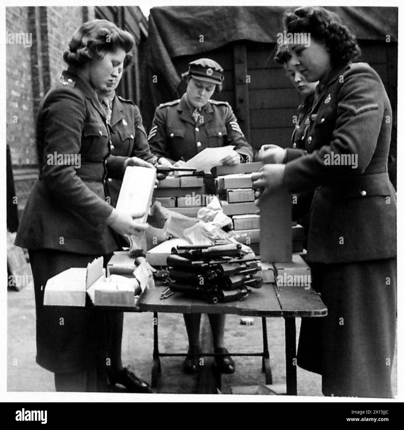 Il personale ATS disimballa e ispeziona i revolver Smith & Wesson .38 forniti dall'America nell'ambito del programma Lend-Lease per l'esercito britannico. Foto Stock