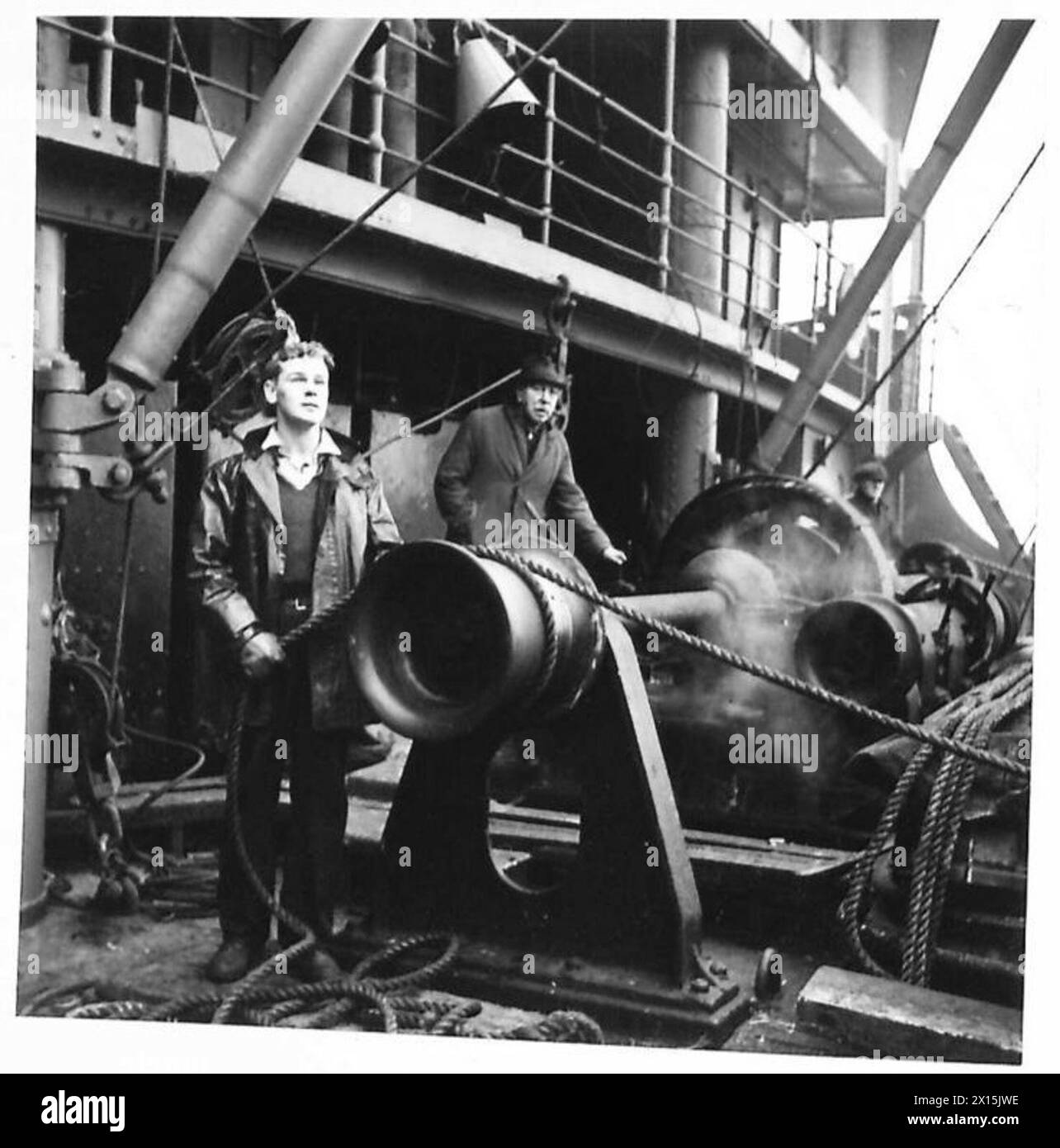 Un verricello aziona la gru per sollevare i veicoli dalla banchina sulle navi mentre le truppe britanniche e americane si imbarcano sotto la supervisione dell'esercito britannico. Foto Stock