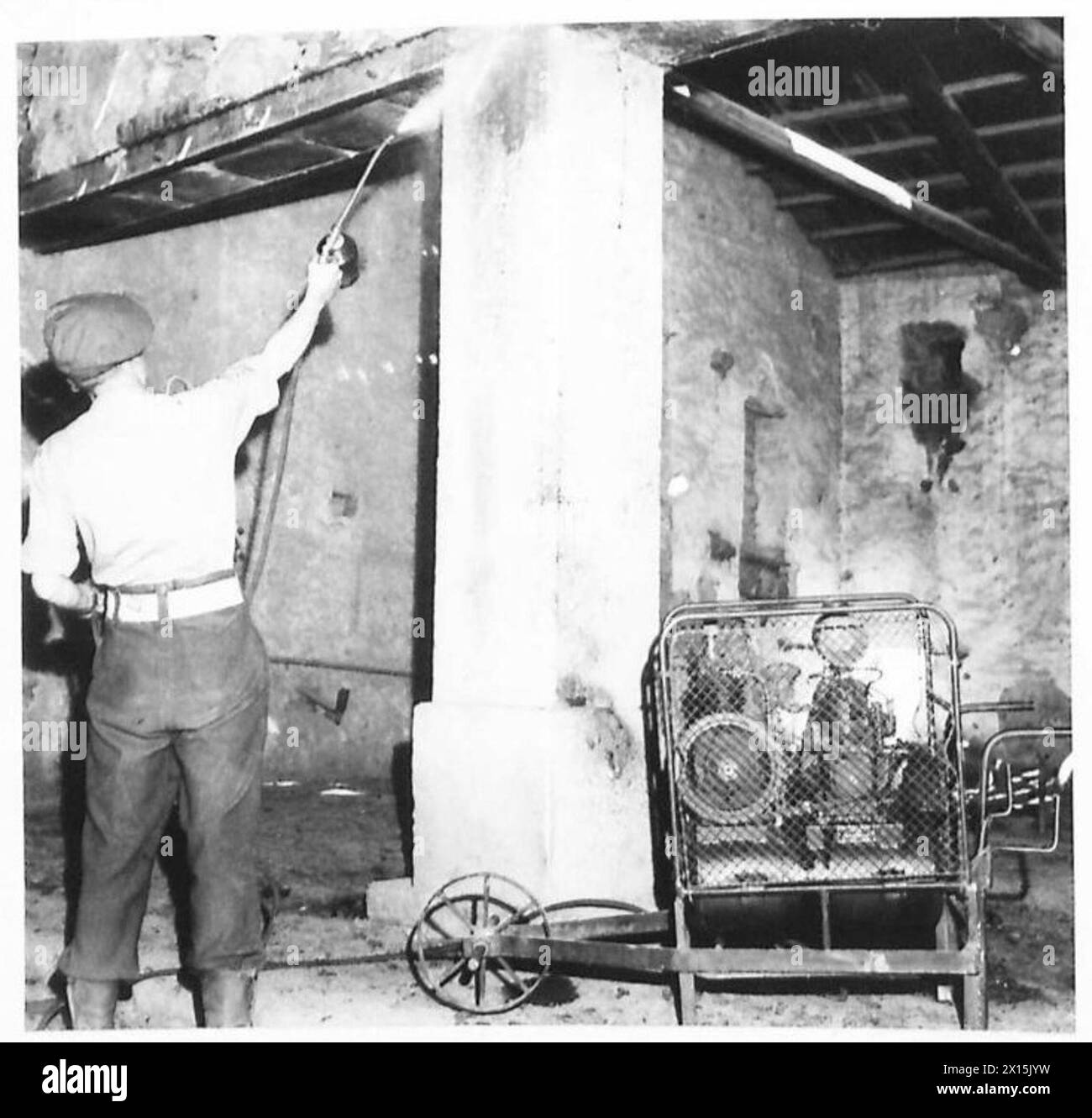 Un piccolo motore aziona uno spruzzo ad alta pressione in un edificio in Grecia per controllare l'allevamento delle zanzare come parte degli sforzi anti-malarici dell'esercito britannico. Foto Stock