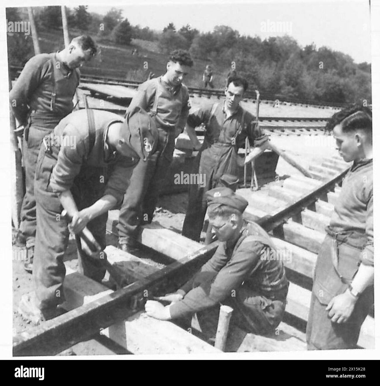 I platelayer dell'esercito imbullonano piastre a pesce che collegano le rotaie su una ferrovia militare in costruzione per la formazione dei Royal Engineers. Foto Stock