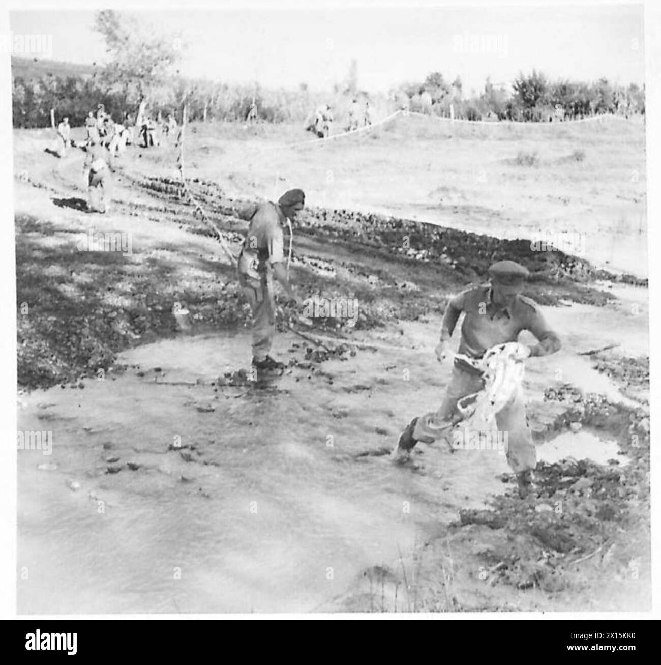 L'ESERCITO BRITANNICO IN NORD AFRICA, SICILIA, ITALIA, BALCANI E AUSTRIA 1942-1946 - dopo che il letto del fiume Rubicon è stato ripulito dalle mine, un ufficiale dei Royal Engineers traccia un percorso chiaro con nastro bianco dell'esercito britannico Foto Stock