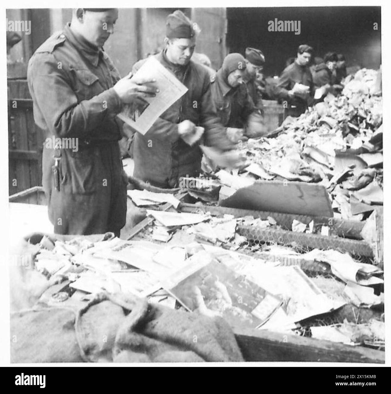 L'esercito britannico conduce operazioni di recupero della carta, maneggiando e imballando con cura vecchi libri, periodici e giornali dopo aver rimosso i fermacavi, evidenziando le procedure di recupero del materiale. Foto Stock