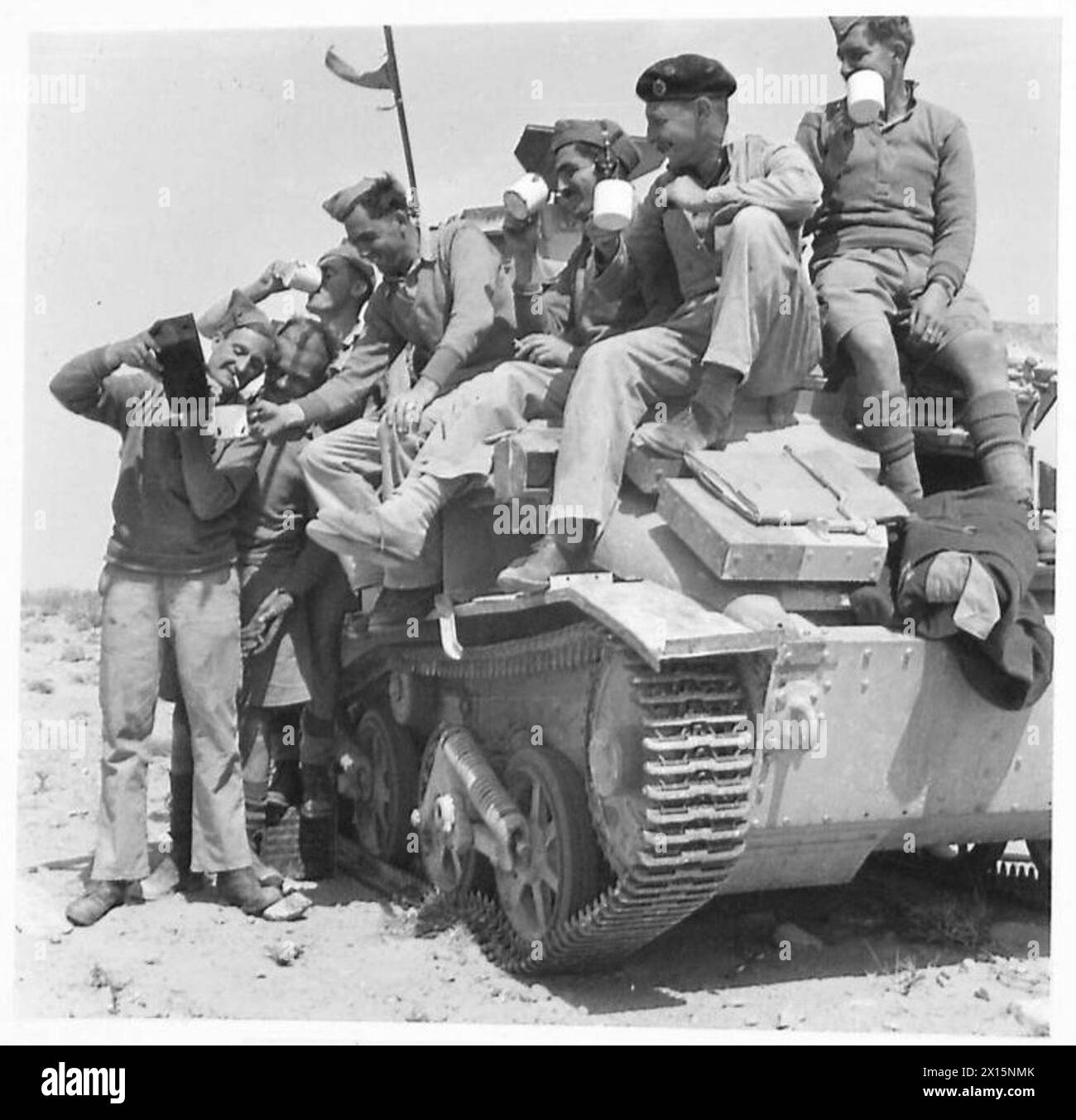 L'equipaggio di un carro armato leggero nel deserto si ferma per bere il tè prima di intraprendere un'azione militare, mettendo in evidenza i preparativi di routine in condizioni operative. Foto Stock