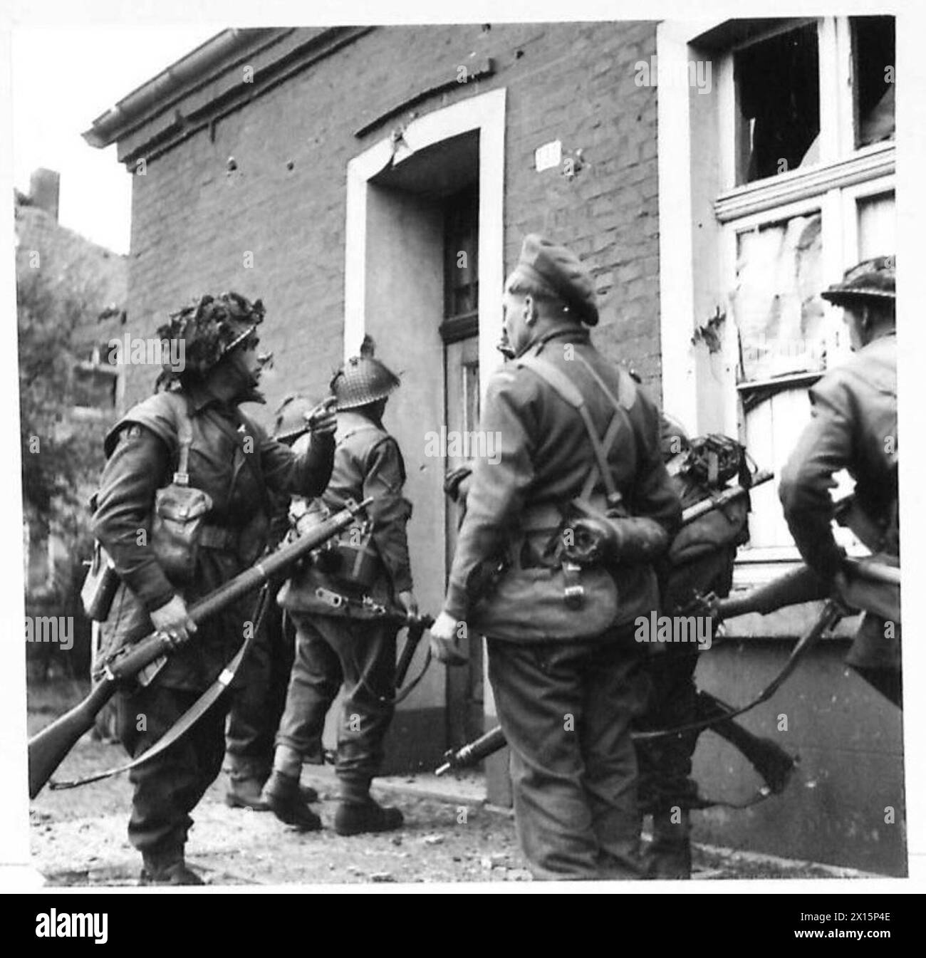 La fanteria del 9th Battalion, Durham Light Infantry, si ferma fuori da una casa durante l'avanzata della 2nd Army sul Reno, mostrando le operazioni di prima linea e i movimenti delle truppe. Foto Stock