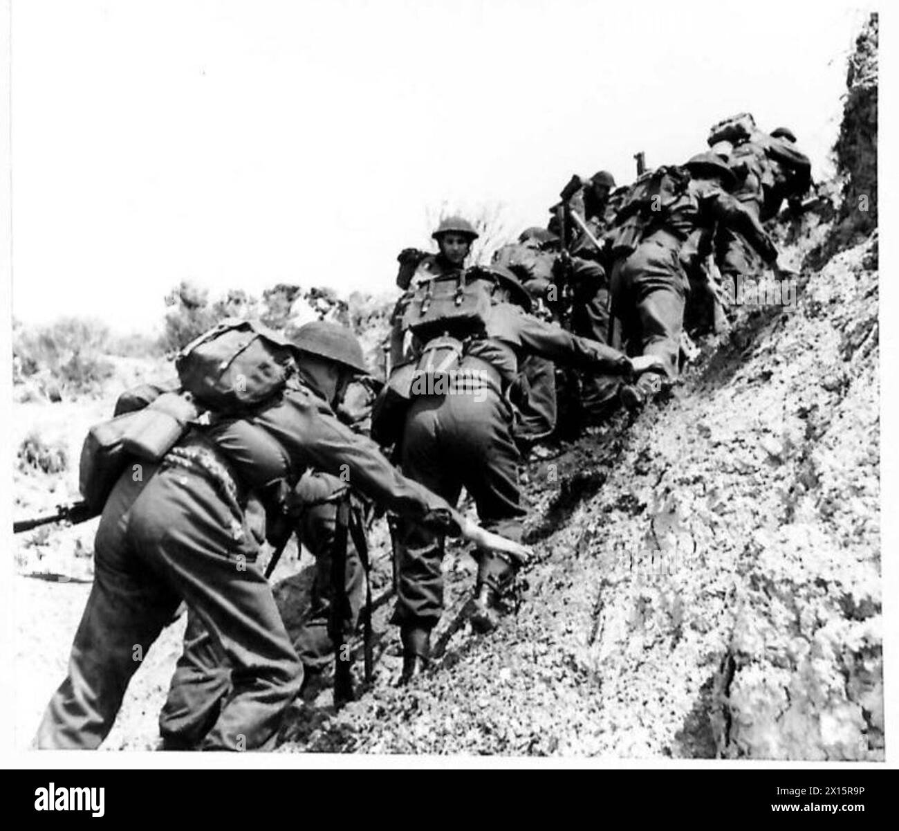 Le truppe dell'esercito britannico scalano le scogliere dopo essere sbarcate da mezzi da sbarco durante un'esercitazione di atterraggio, esercitando manovre sul campo e coordinandosi. Foto Stock