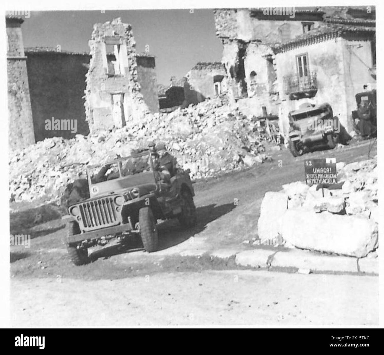 Il generale Kazimierz Sosnkowski entra a Rionero in Vulture ispezionando le unità della 3a Divisione fucilieri dei Carpazi, 2° corpo polacco. Un cartello stradale indica che l'area è sotto osservazione nemica, marzo 1944. Foto Stock