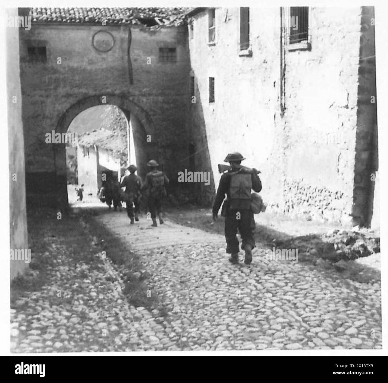 Un plotone della "C" Company, 2/4 Gurkhas, si muove attraverso un arco a Sogliano al Rubicone durante le operazioni dell'esercito britannico. Foto Stock