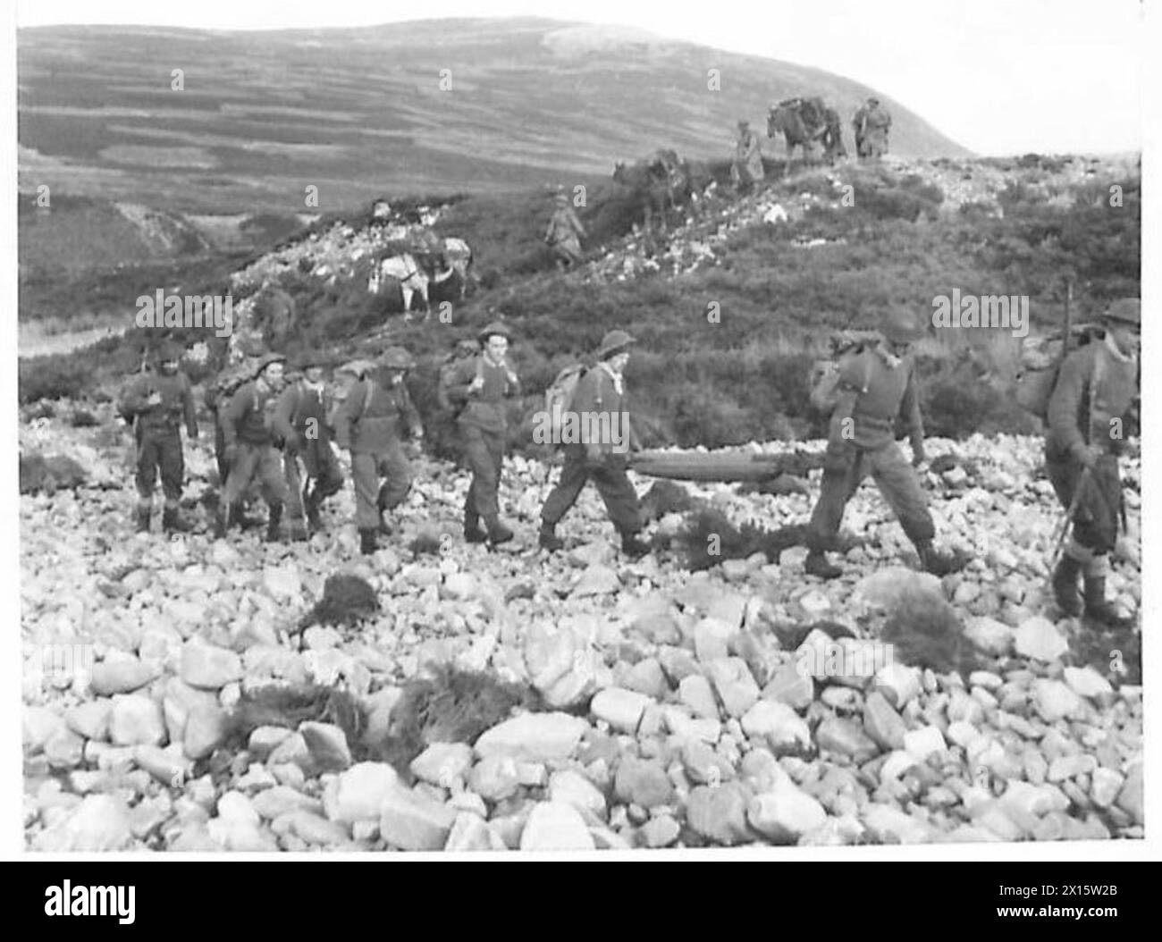 Truppe, accompagnate da muli, massi attraversati e terreni montuosi durante un'esercitazione di guerra in montagna, simulando l'impegno con le forze nemiche. Foto Stock