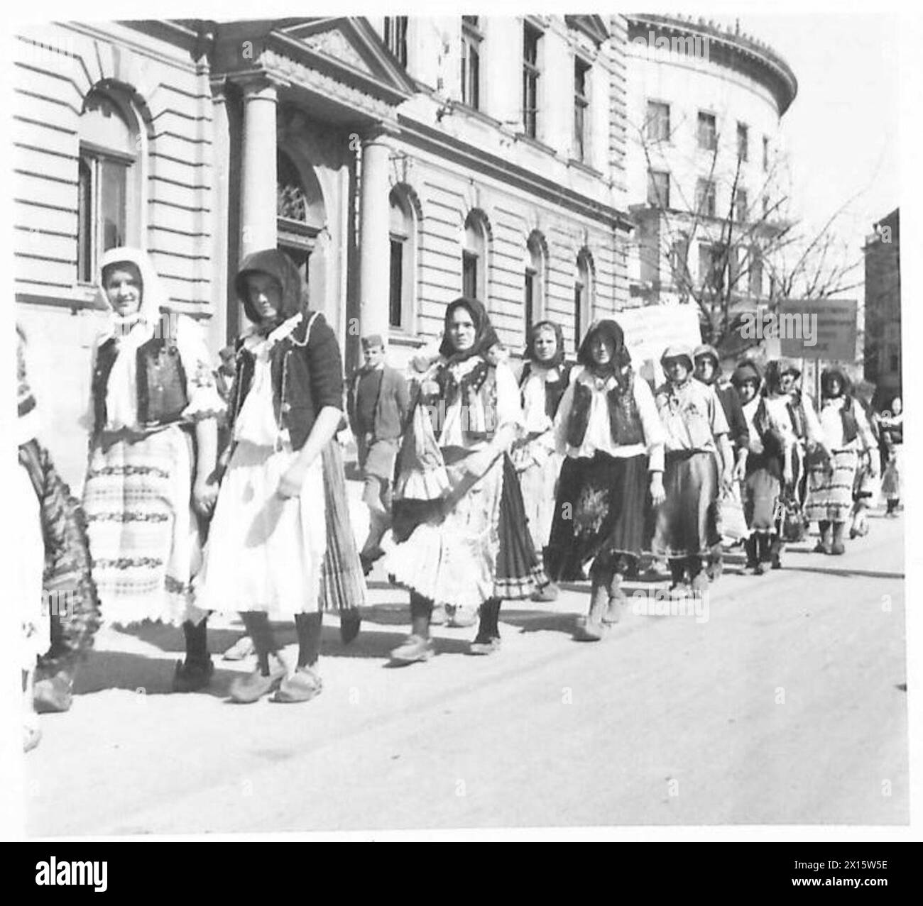 Le ragazze che indossano costumi nazionali marciano verso un luogo d'incontro designato a Belgrado durante un evento organizzato dall'esercito britannico, dimostrando la cultura locale e l'attività cerimoniale. Foto Stock