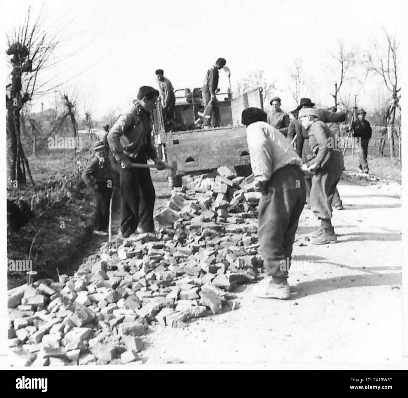 I lavoratori italiani lavorano alla ricostruzione delle strade nell'area controllata dall'Ottava Armata britannica durante la seconda guerra mondiale Foto Stock