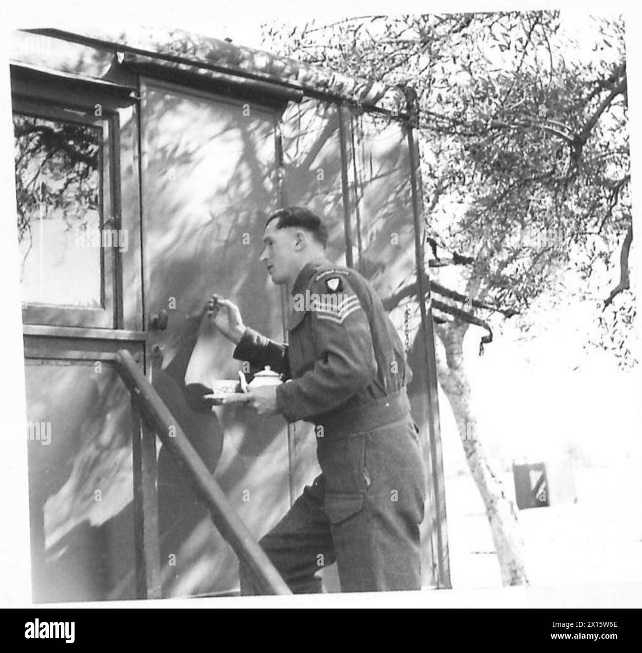 Alle 7:00, al generale Leese viene servita una tazza di tè mattutina dal sergente Lamb a seguito di una richiesta del Ministero dell'informazione, osservata dal personale dell'esercito britannico in Italia. Foto Stock