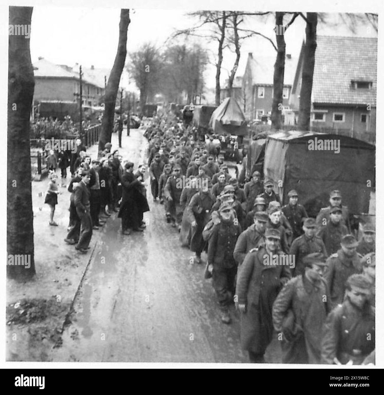 450 prigionieri tedeschi catturati nel settore Reichwald dalla 53a divisione durante l'operazione Veritable vengono marciati e trasportati in camion dell'esercito, osservati dai civili olandesi, compresi i bambini, sotto il 21st Army Group britannico. Foto Stock