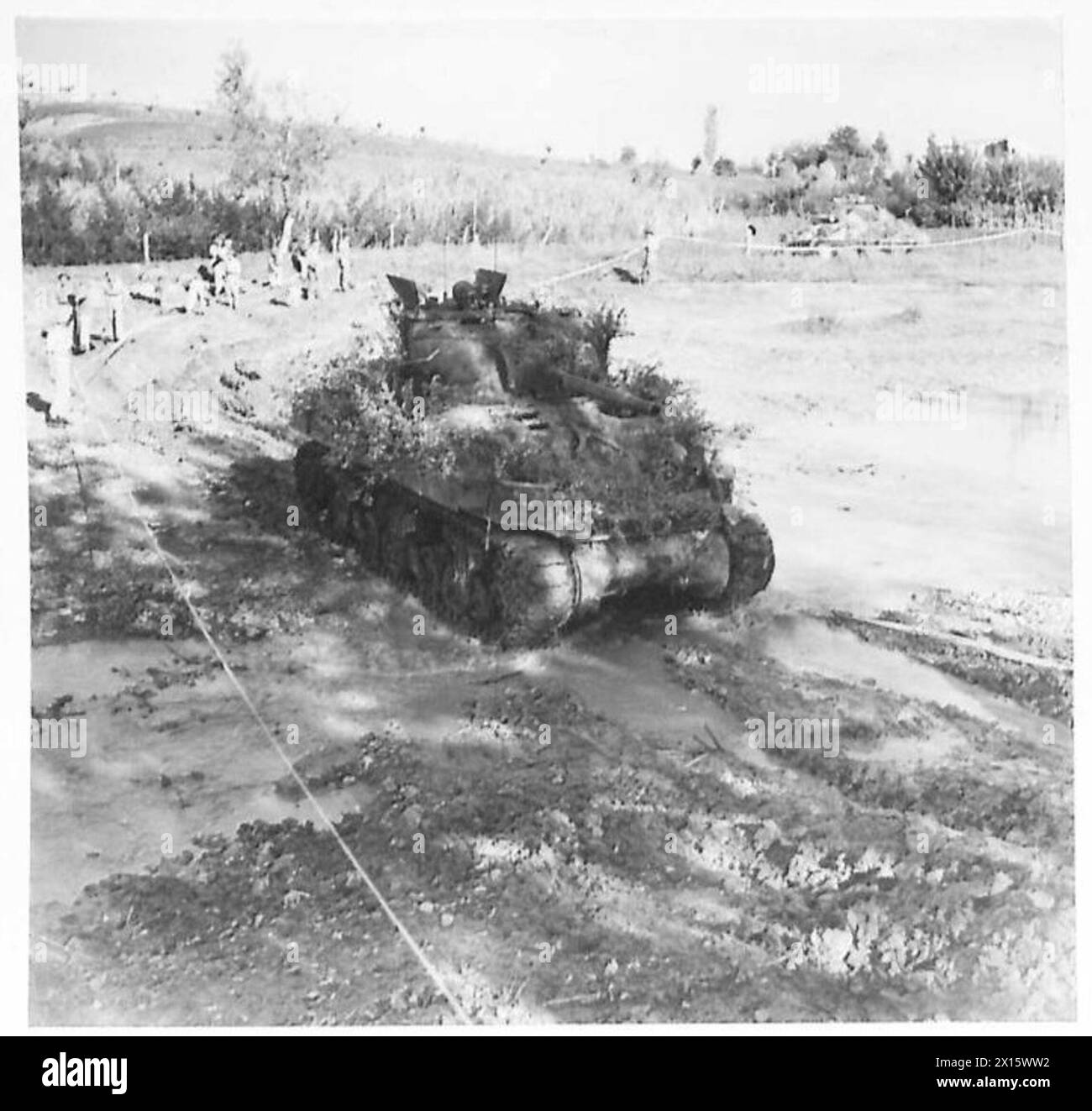 Gli ingegneri lavorano sulle rive del fiume Rubicon, livellandole per il trasporto, mentre i carri armati del 2° R.T.R. attraversano il letto del fiume senza mine, illustrando la logistica e il movimento corazzato. Foto Stock